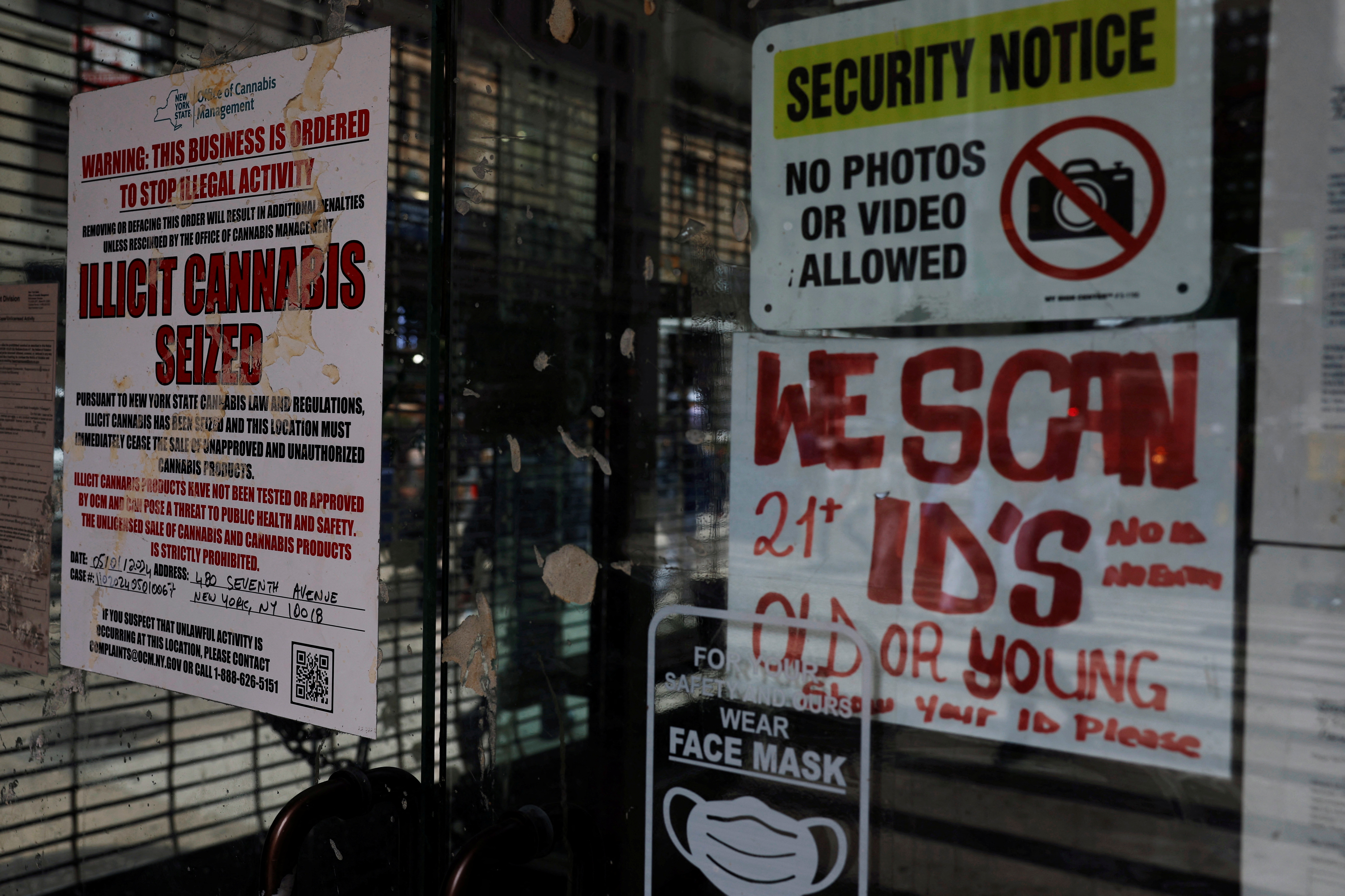 Signs hang posted at an illicit cannabis store.