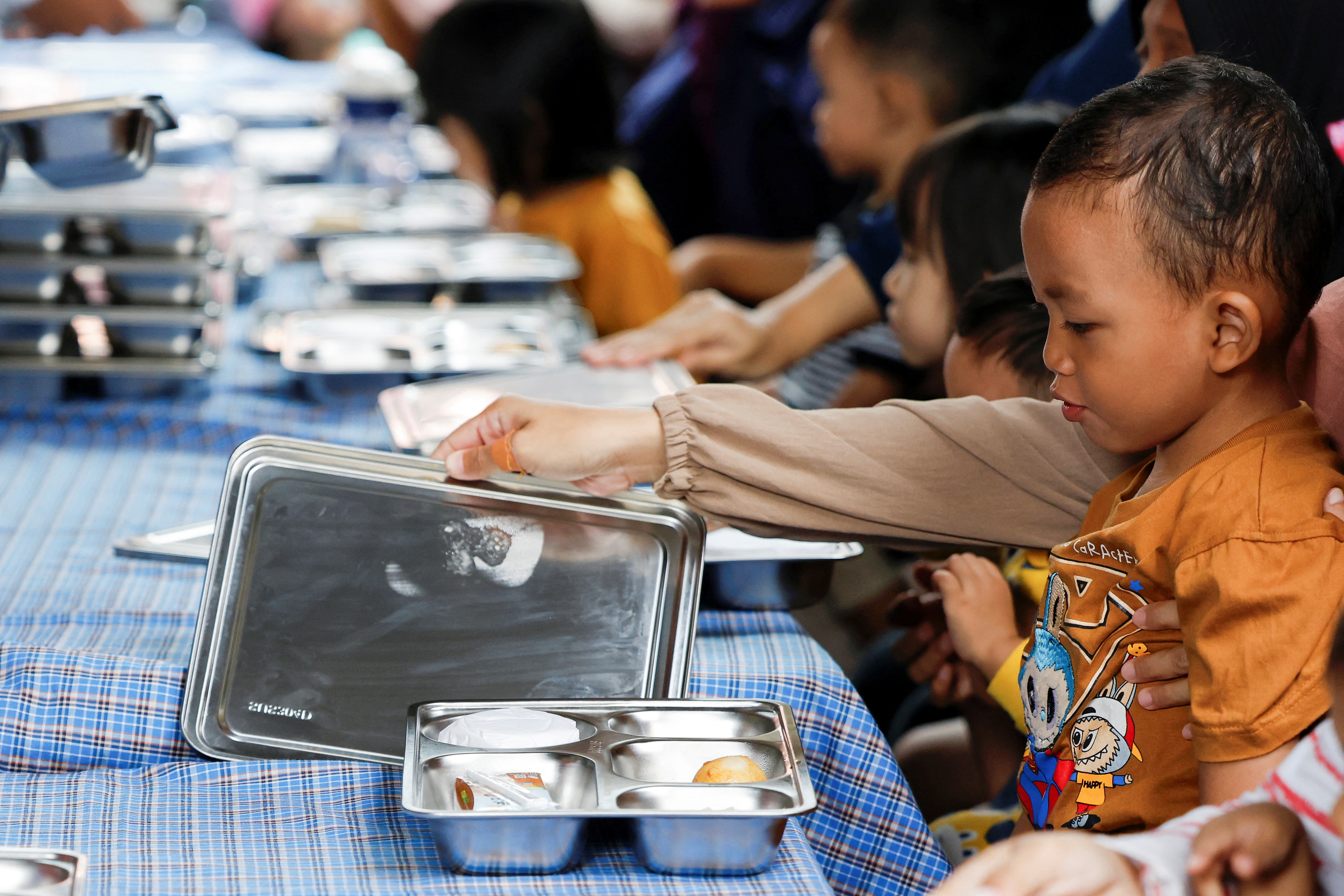 A boy reacts as he looks at his meal during the free nutritious meals program in Jakarta, Indonesia, January 10, 2025. REUTERS/Ajeng Dinar Ulfiana