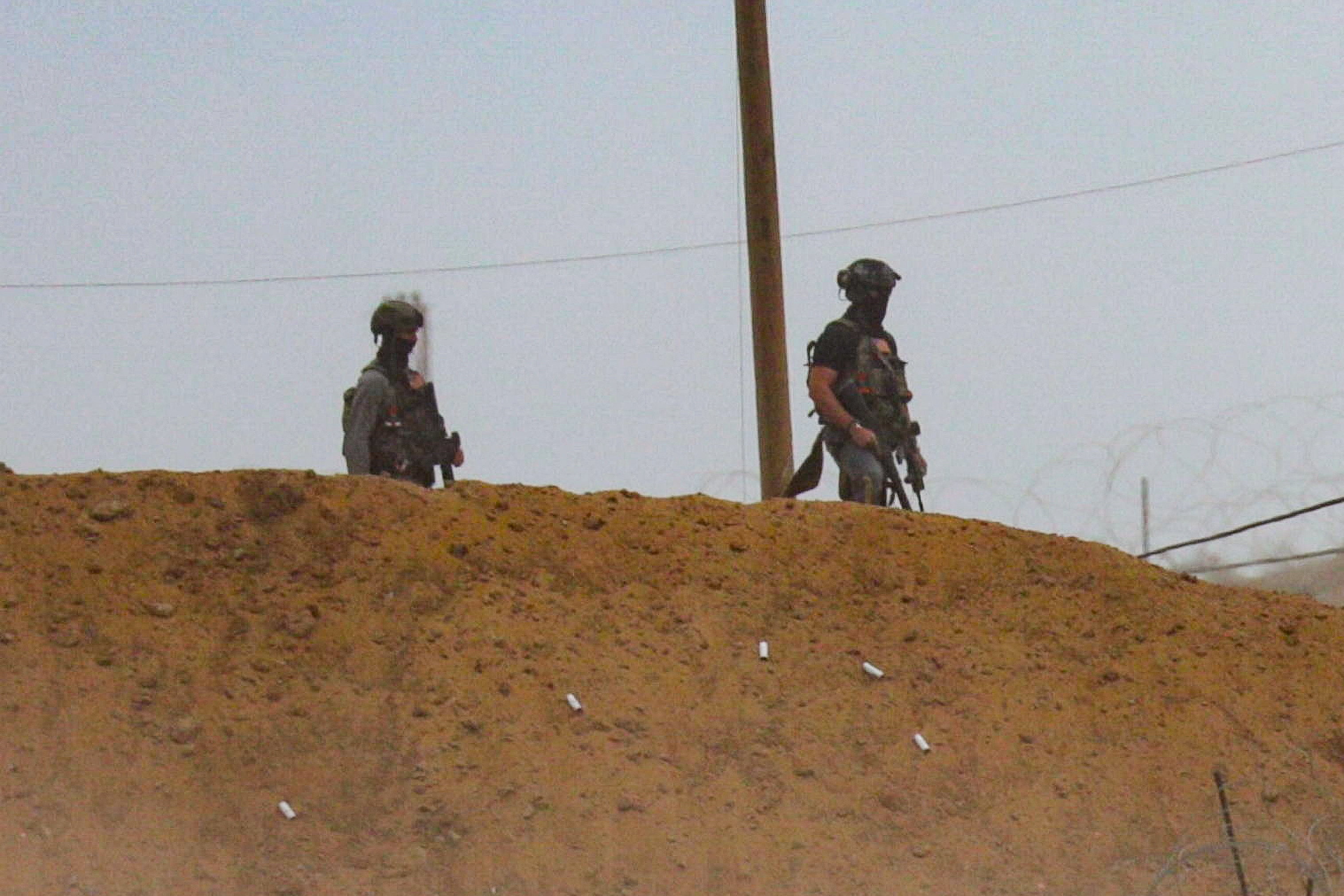 Security contractors of the U.S.-backed Gaza Humanitarian Foundation (GHF) stand guard as Palestinians receive aid supplies from GHF, in the central Gaza Strip, August 1, 2025. REUTERS/Stringer