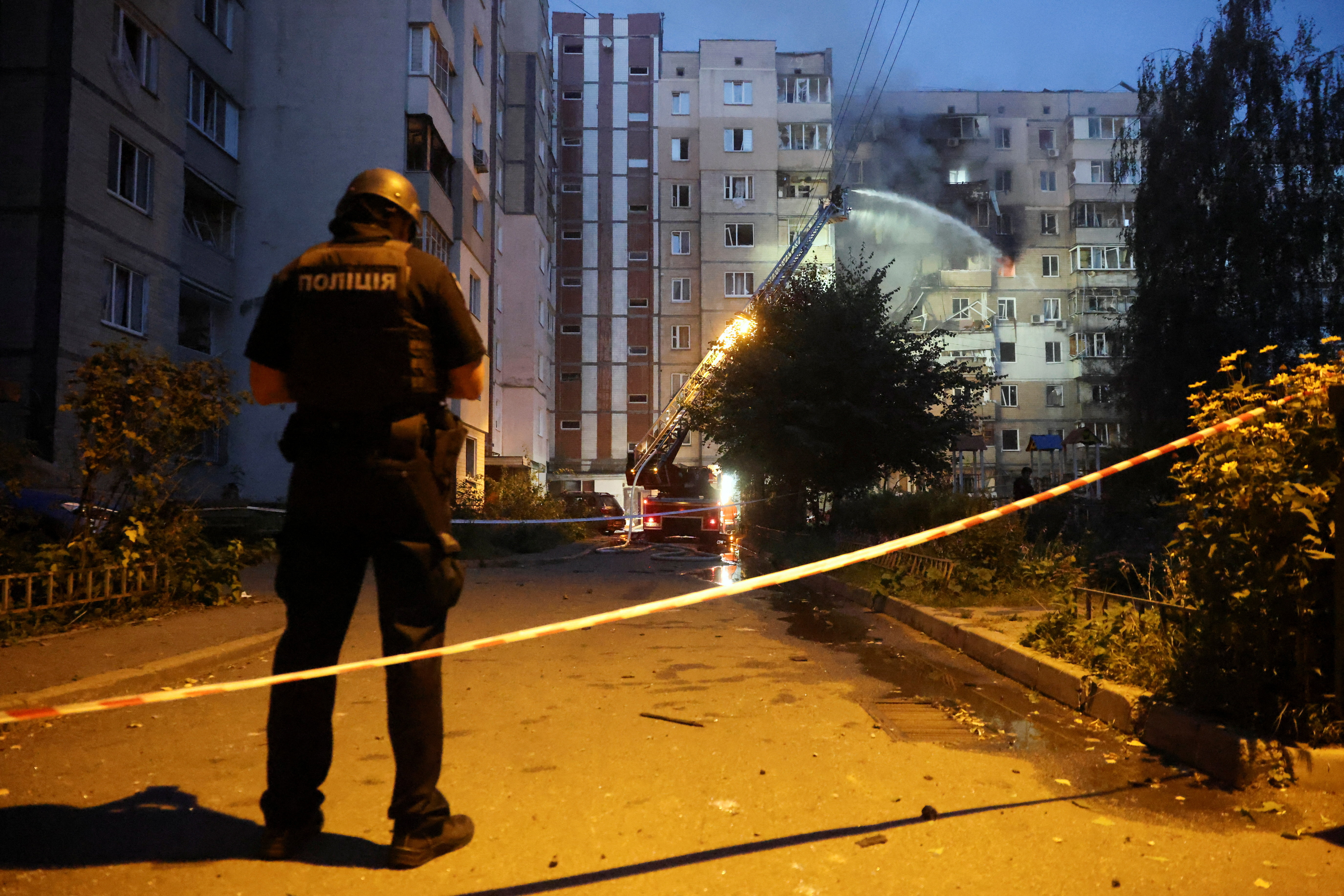 A police officer stands near the site of an apartment building damaged during a Russian drone strike, amid Russia’s attack on Ukraine, in Kyiv, Ukraine September 7, 2025. REUTERS/Thomas Peter
