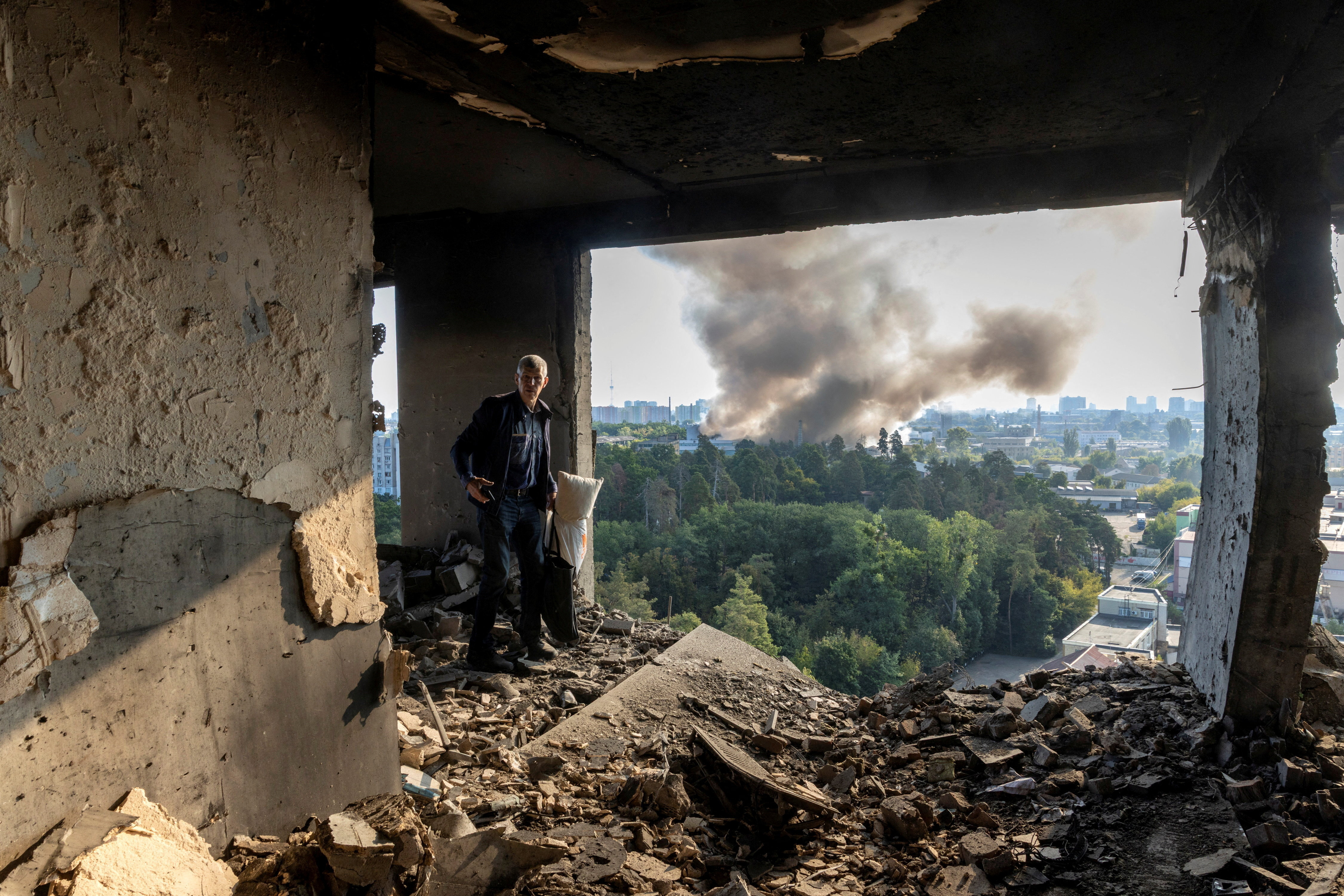 A friend of the owner inspects the damage in an apartment that was hit during a Russian drone strike