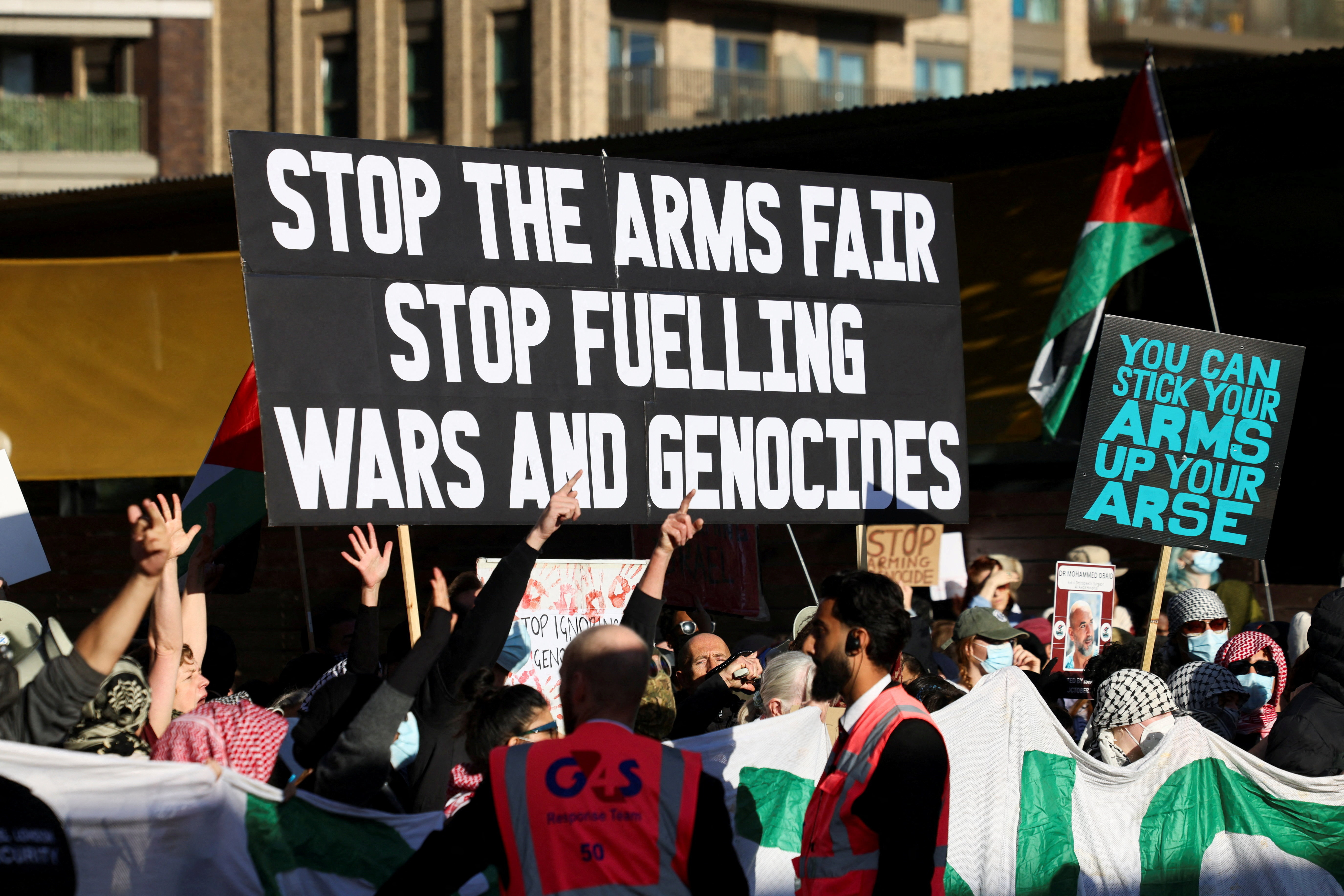 Demonstrators hold up signs and Palestinian flags during a protest against UK arms exports to Israel in London