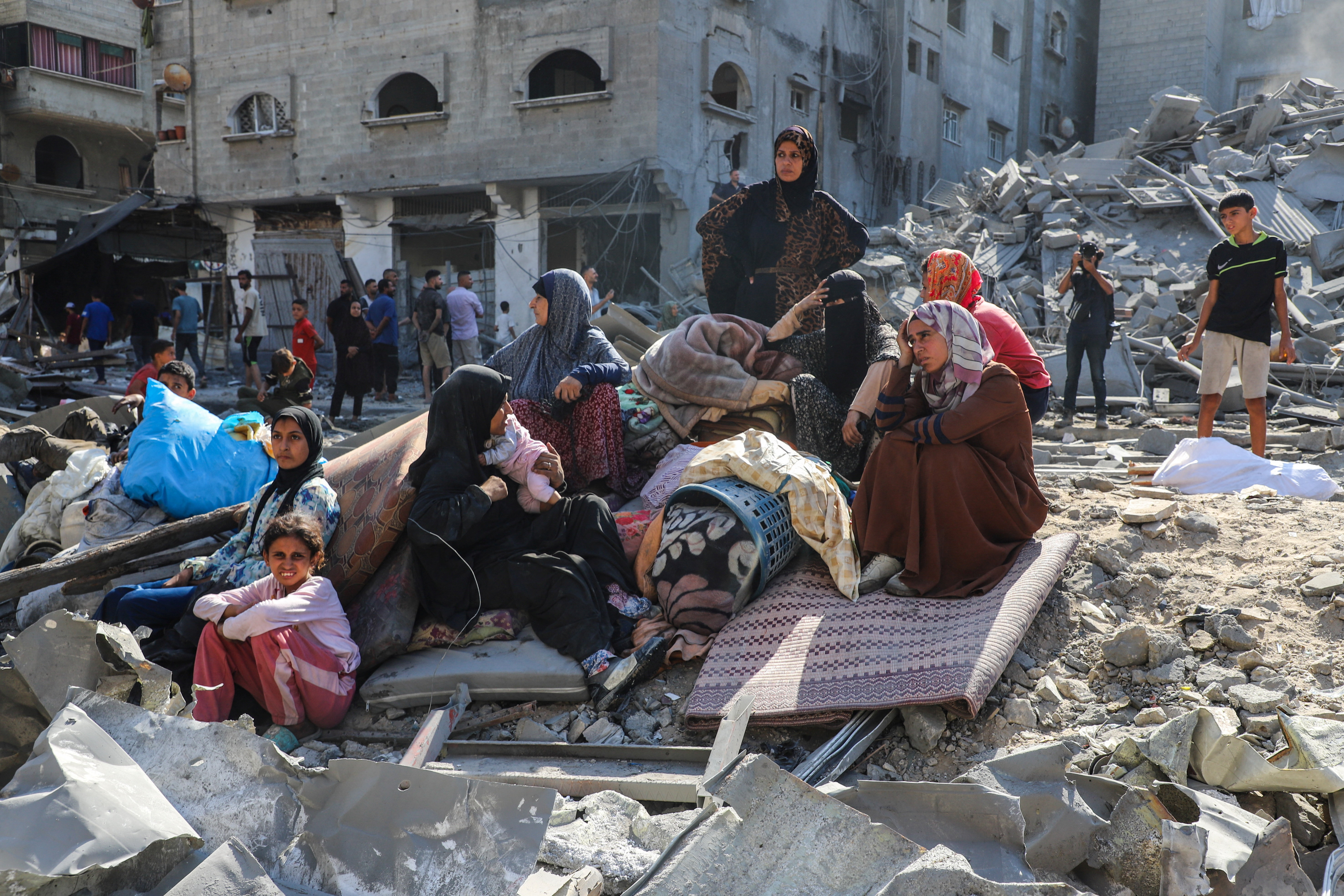 Palestinians inspect the site of Israeli air strikes on houses, at al-Shati refugee camp