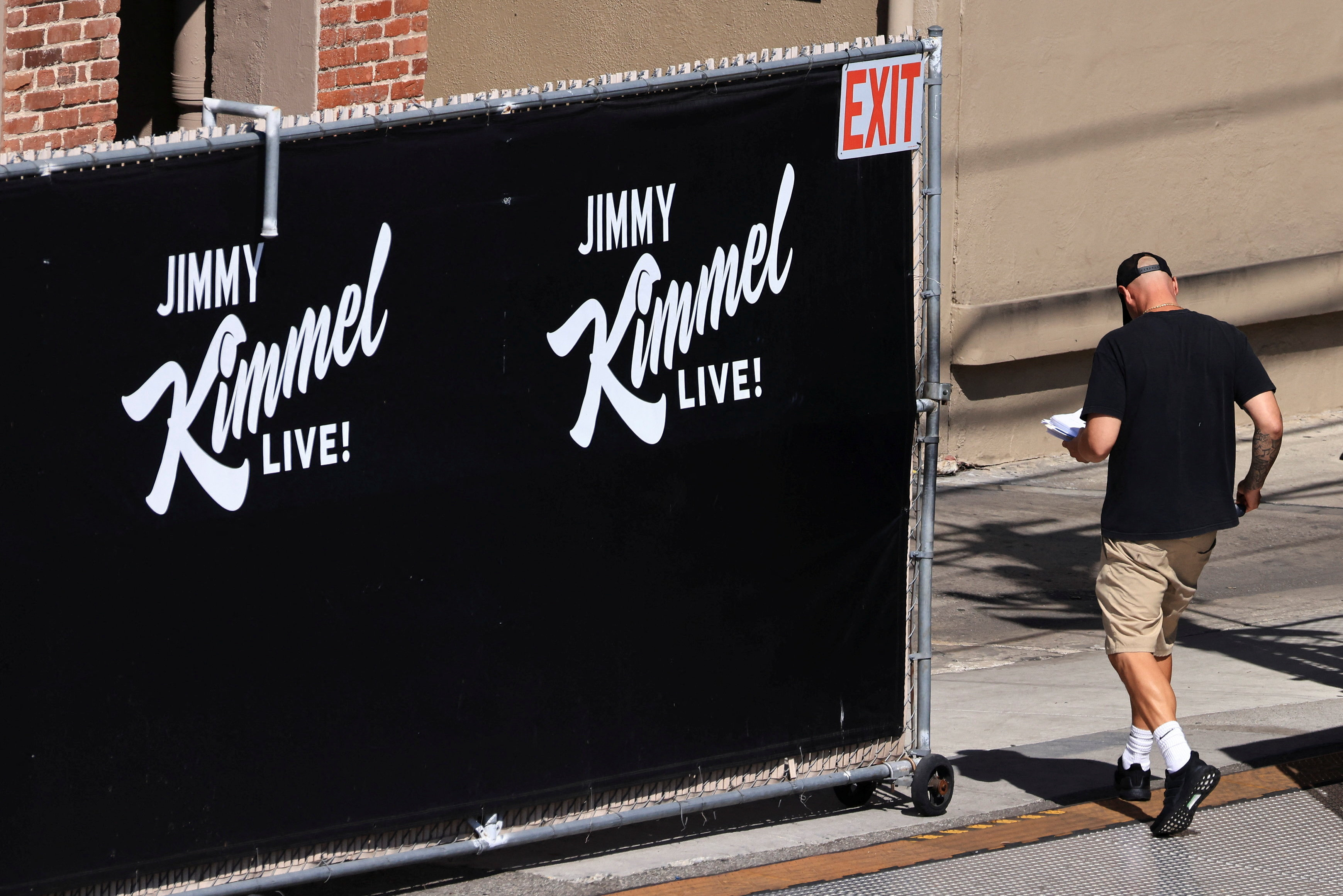 A person walks towards the theatre where Jimmy Kimmel Live! was recorded for broadcast following announcement on September 22 by Disney that the show will return to its ABC network lineup on Tuesday, in Los Angeles, California, US [David Swanson/Reuters]