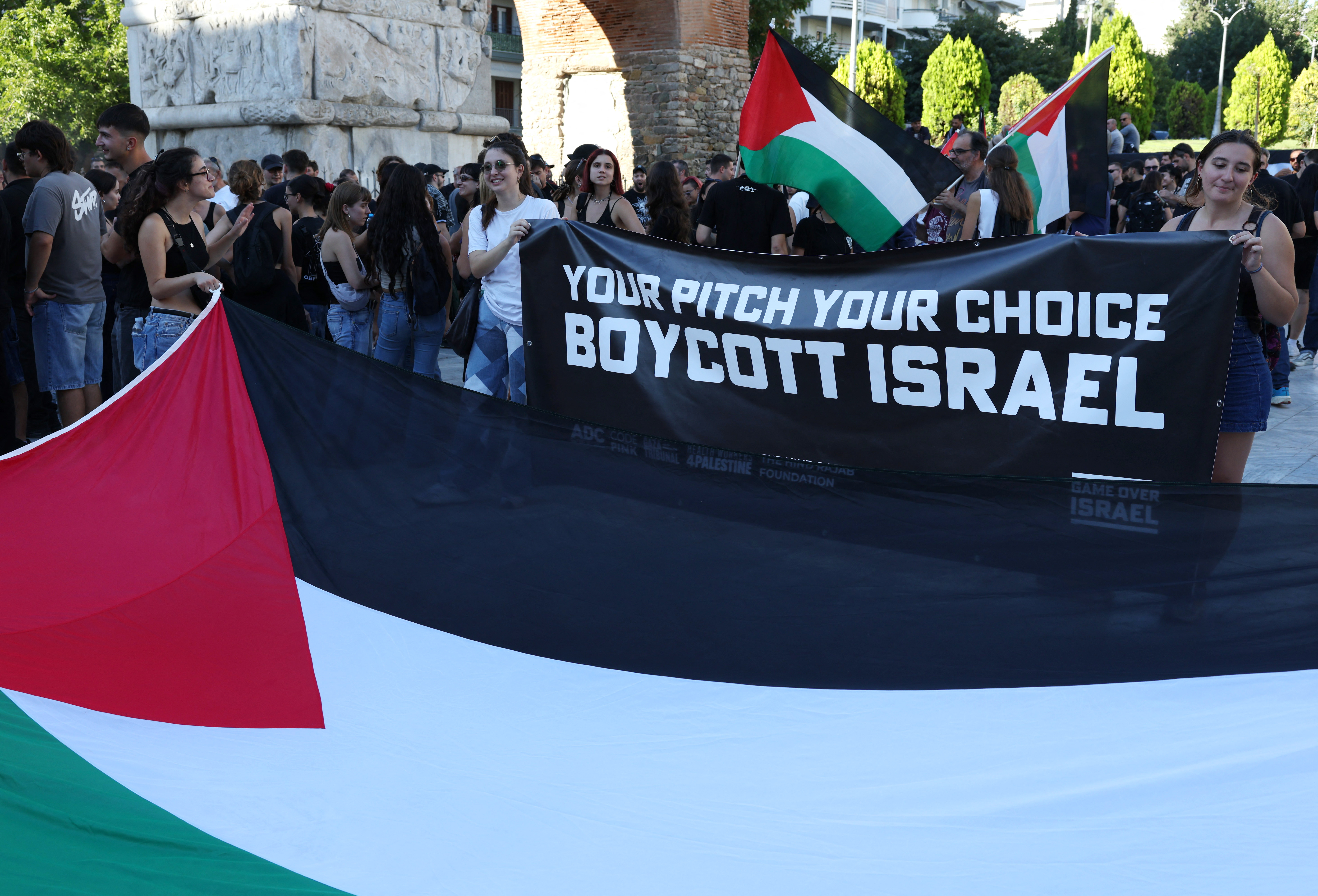 Soccer Football - UEFA Europa League - PAOK fans gather in the city center to protest against Maccabi Tel Aviv - Thessaloniki, Greece - September 24, 2025 General view of a Palestine flag as a banner is displayed during the protest reading "your pitch your choice boycott Israel" REUTERS/Murad Sezer