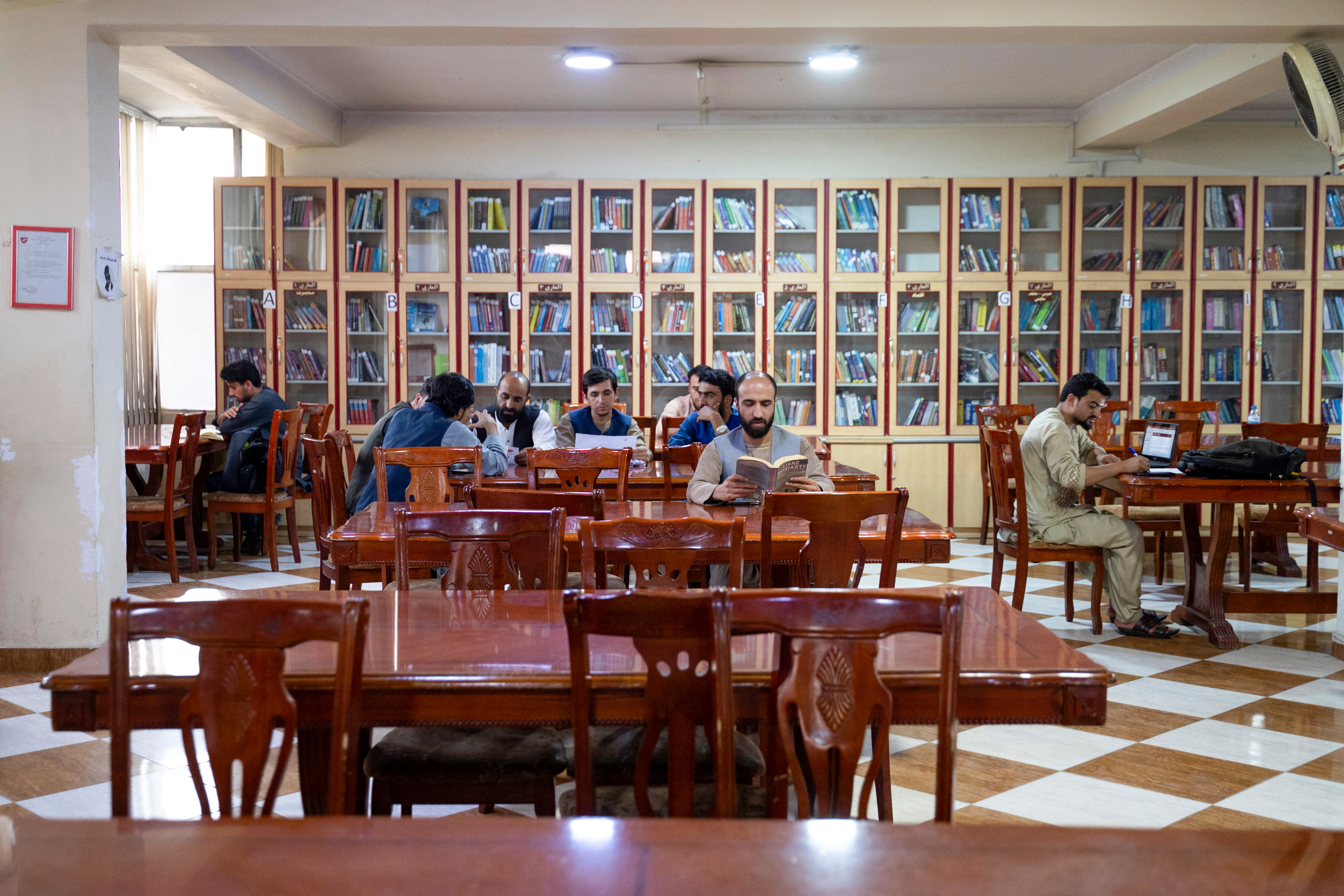 Men read books in a library at a private university in Kabul.