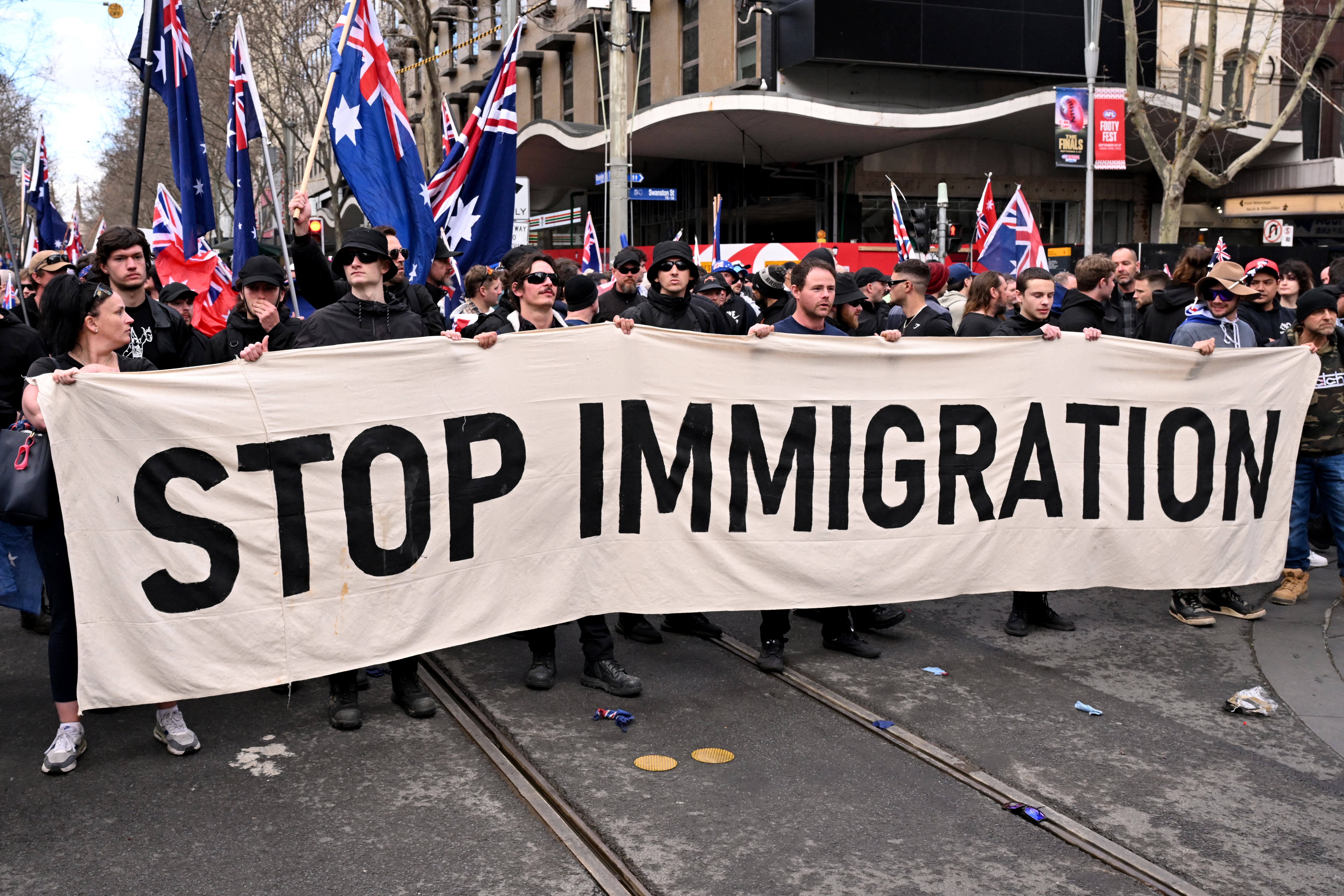 Protesters hold a banner during a "March for Australia" anti-immigration rally in Melbourne on August 31, 2025. (Photo by William WEST / AFP)
