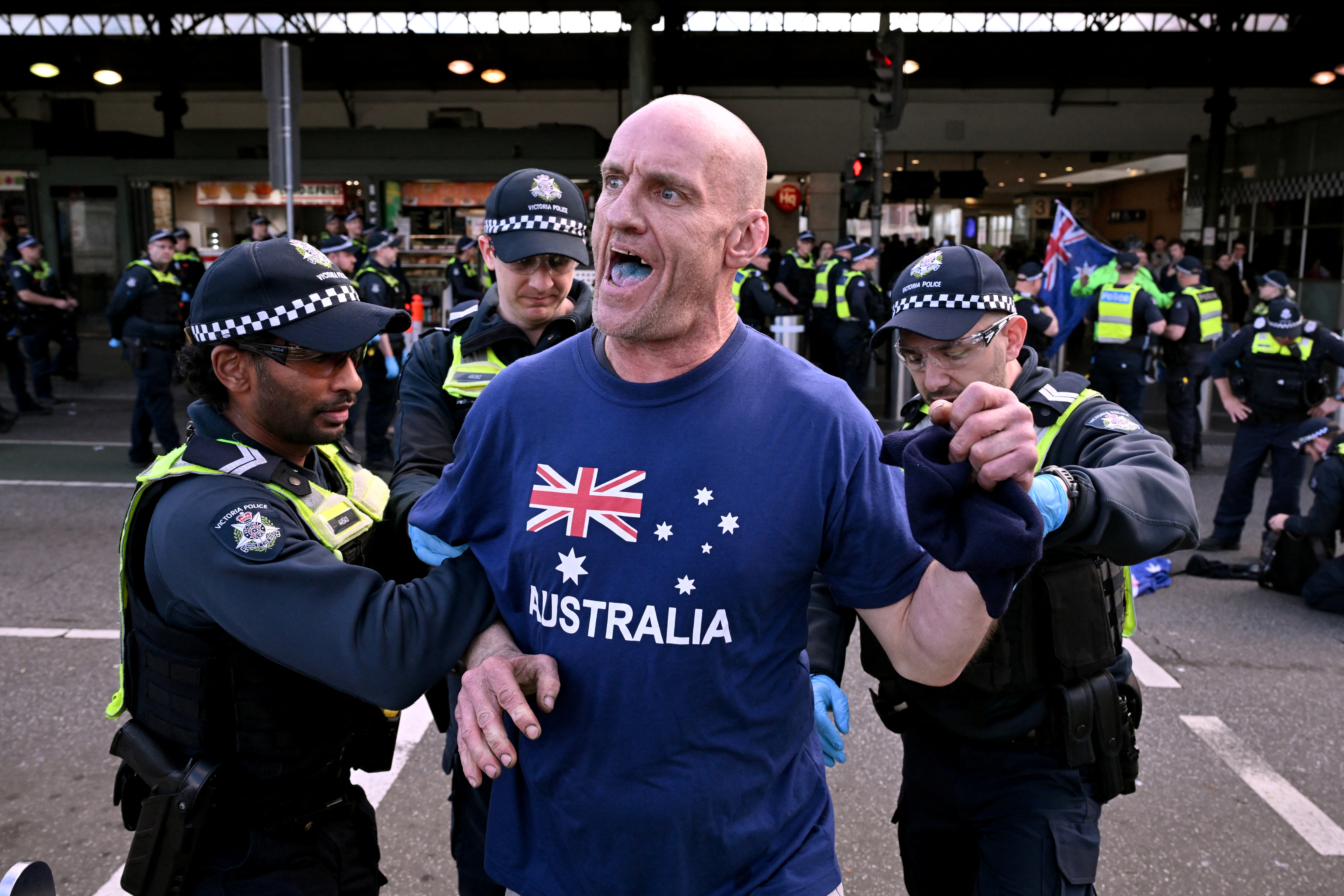 Police detain a protester during a "March for Australia" anti-immigration rally in Melbourne on August 31, 2025.