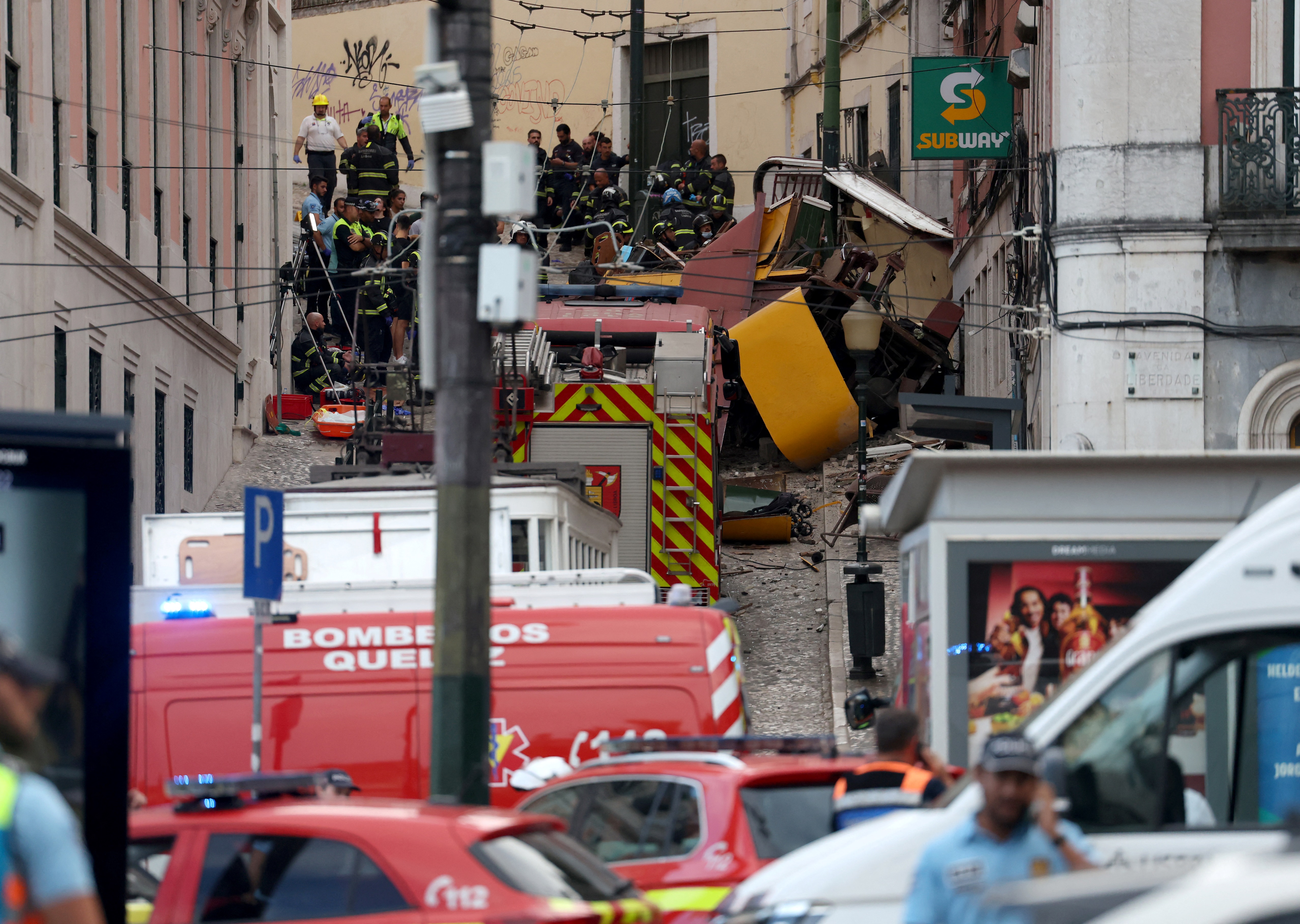 Police and firefighters work on the site of the Gloria funicular railway accident in Lisbon