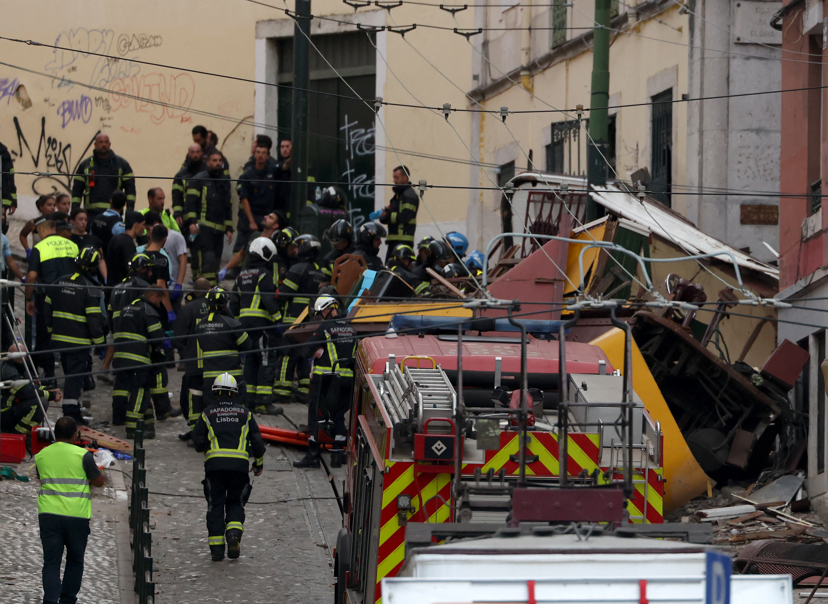 Police and firefighters work on the site of the Gloria funicular railway accident in Lisbon
