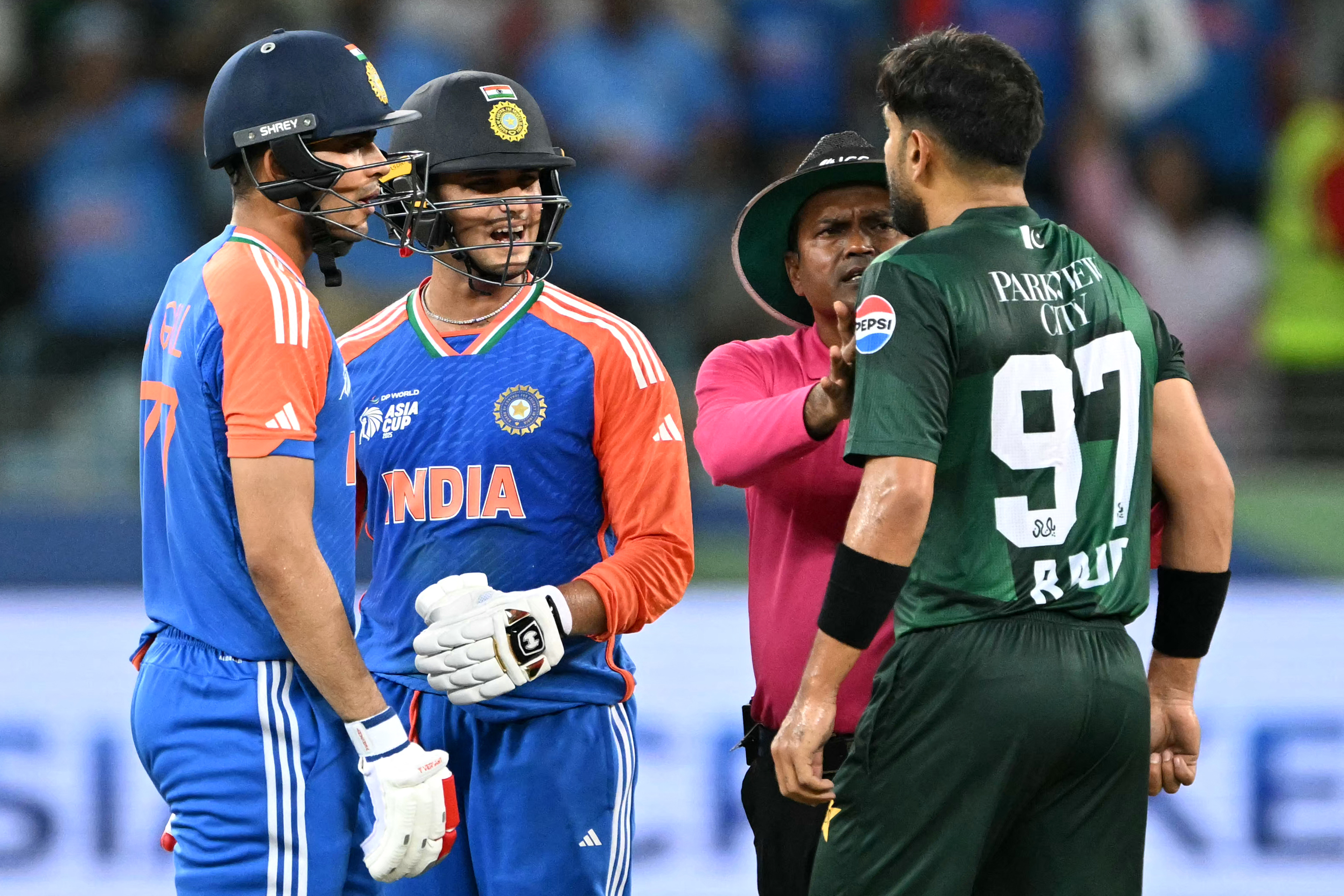 Pakistan's Haris Rauf (R) speaks with India's Abhishek Sharma (2L) as Shubman Gill watches during the Asia Cup 2025 Super Four Twenty20 international cricket match between India and Pakistan at the Dubai International Stadium in Dubai on September 21, 2025. (Photo by Sajjad HUSSAIN / AFP)