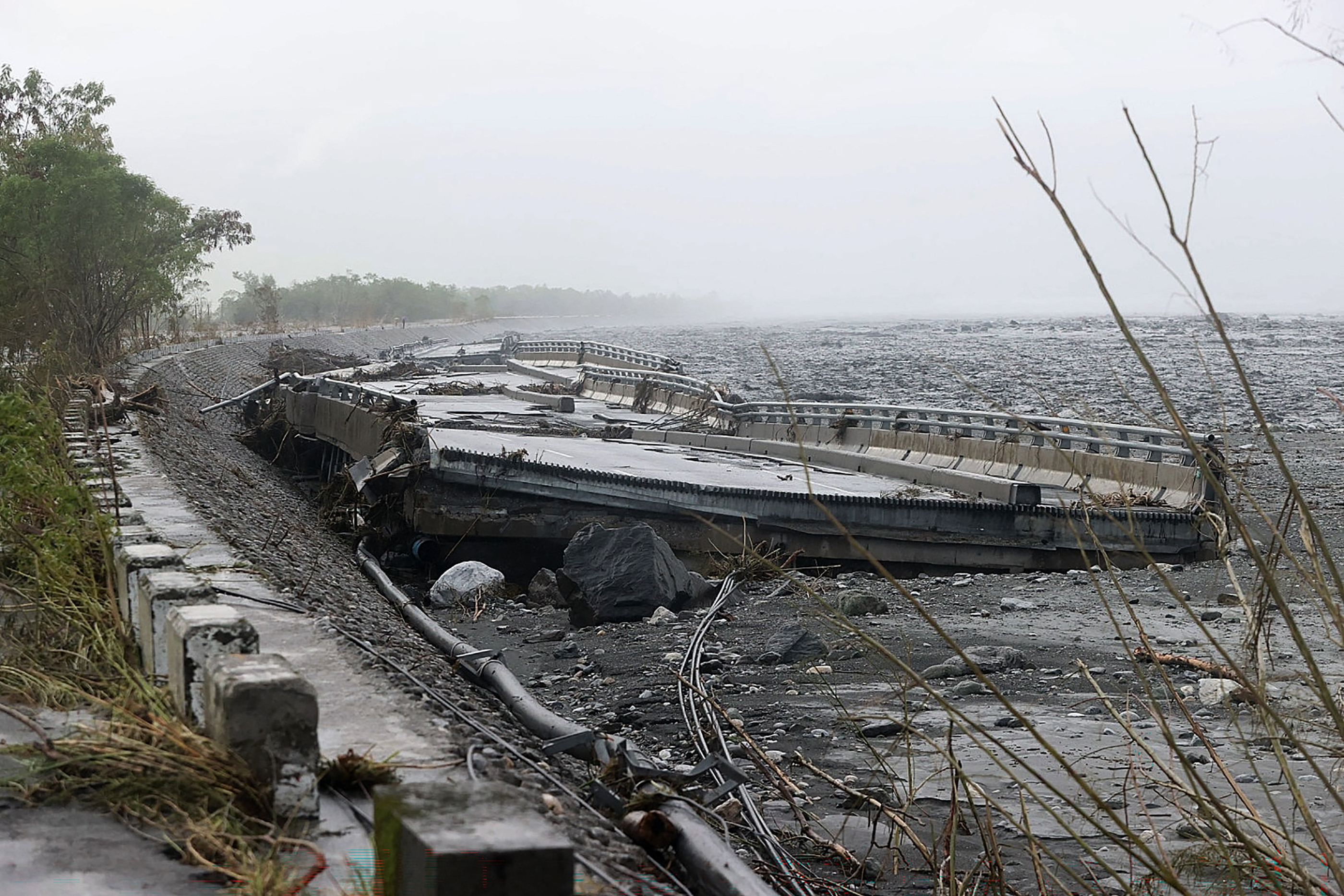 Part of the bridge over Mataian Creek is seen destroyed after a barrier lake burst in Hualien on September 24, 2025. The bursting of the barrier lake in Taiwan killed at least 14 people, regional officials said on September 24 after Super Typhoon Ragasa pounded the island with torrential rains. (Photo by Taiwan's Central News Agency (CNA) / AFP) / - Taiwan OUT - China OUT - Macau OUT / - TAIWAN OUT - CHINA OUT - MACAU OUT / - TAIWAN OUT - CHINA OUT - MACAU OUT / HONG KONG OUT 