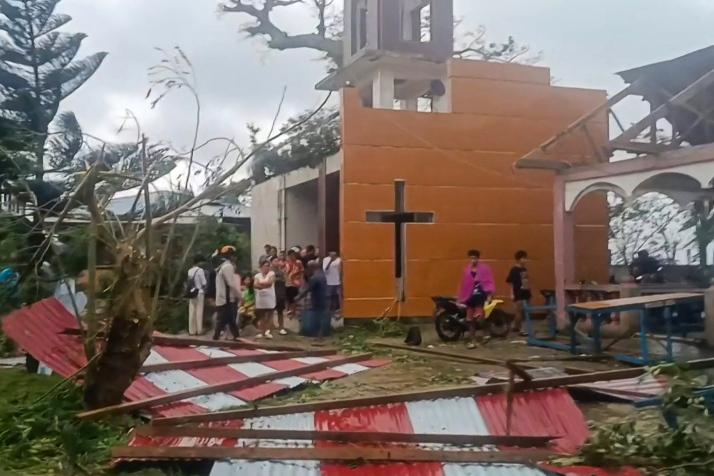 This screen grab taken from UGC video footage courtesy of Facebook user Jerome Martinez taken and received on September 26, 2025 shows people looking at the damage caused by Severe Tropical Storm Bualoi to the Parish of the Immaculate Concepcion Church in Batuan town, Masbate province. The Philippines evacuated hundreds of thousands of people and confirmed at least three deaths on September 26 as the severe tropical storm battered a country still feeling the effects of Super Typhoon Ragasa. (Photo by Handout / various sources / AFP) / NO USE AFTER OCTOBER 5, 2025 04:34:30 GMT - RESTRICTED TO EDITORIAL USE - MANDATORY CREDIT "AFP PHOTO/COURTESY OF FACEBOOK USER JEROME MARTINEZ /HANDOUT - NO MARKETING NO ADVERTISING CAMPAIGNS - DISTRIBUTED AS A SERVICE TO CLIENTS - NO ARCHIVE