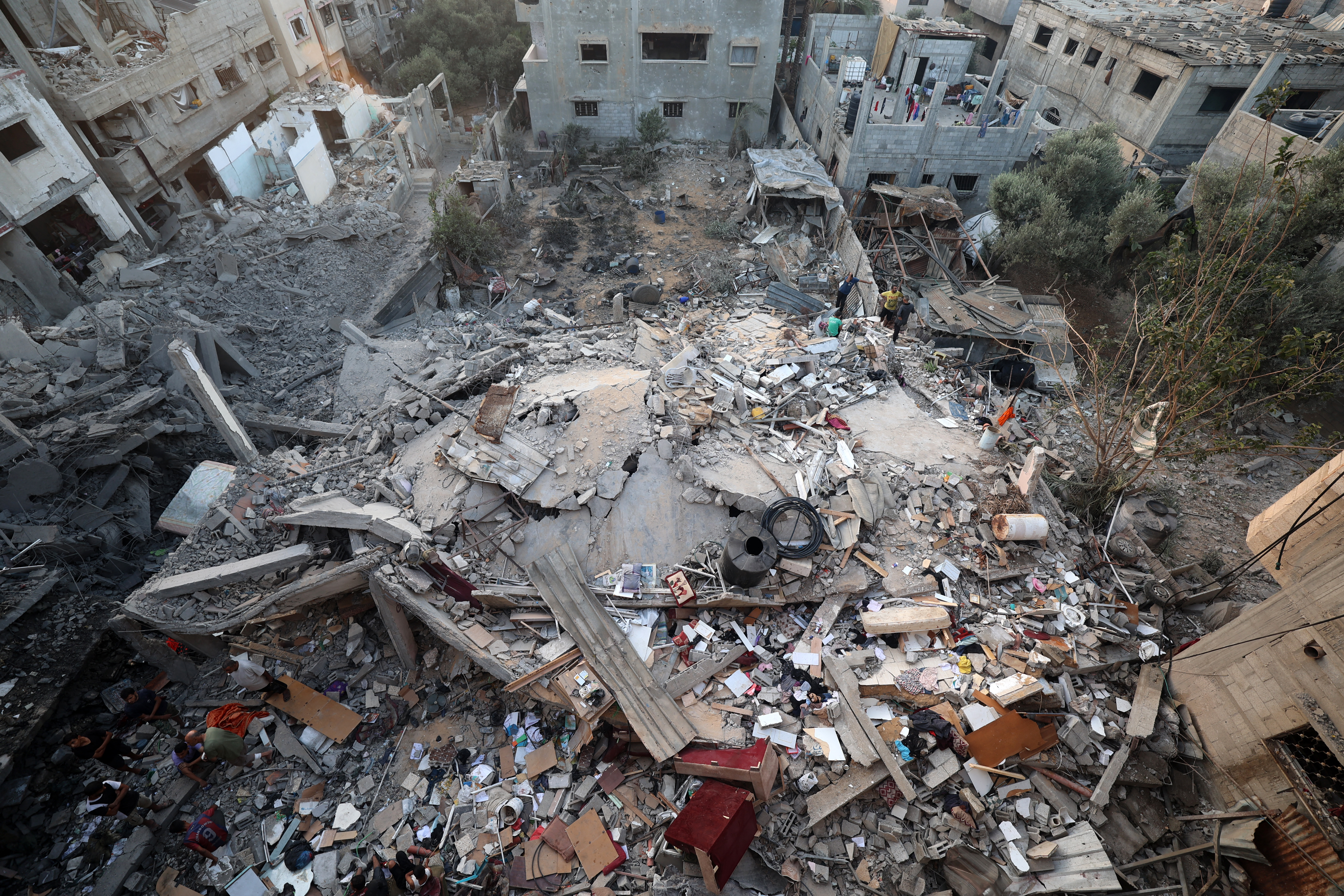In this aerial view, Palestinians check the rubble of a building destroyed by an Israeli strike in the Nuseirat refugee camp in the central Gaza Strip