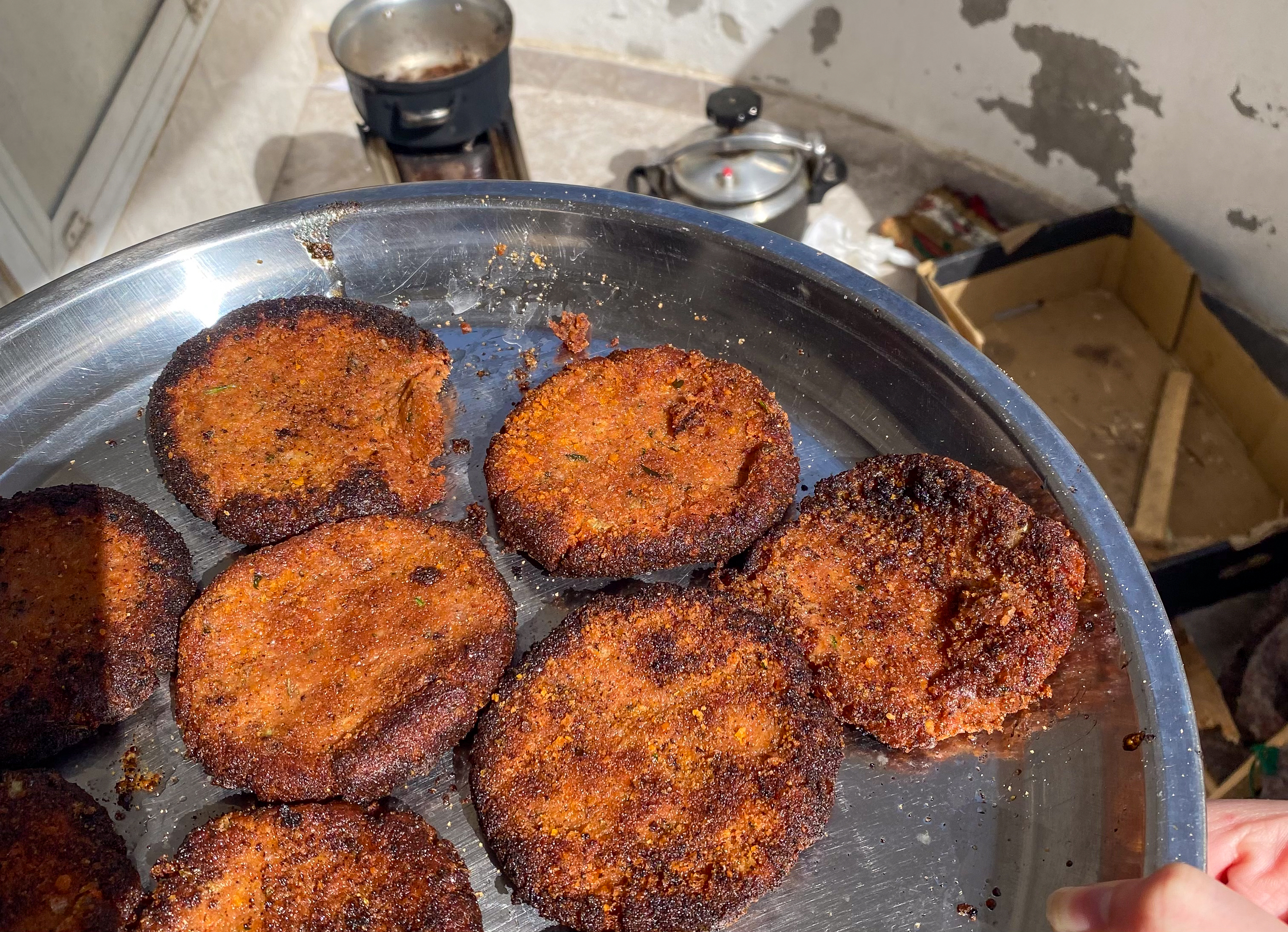 a metal tray of crumbly-looking fried patties