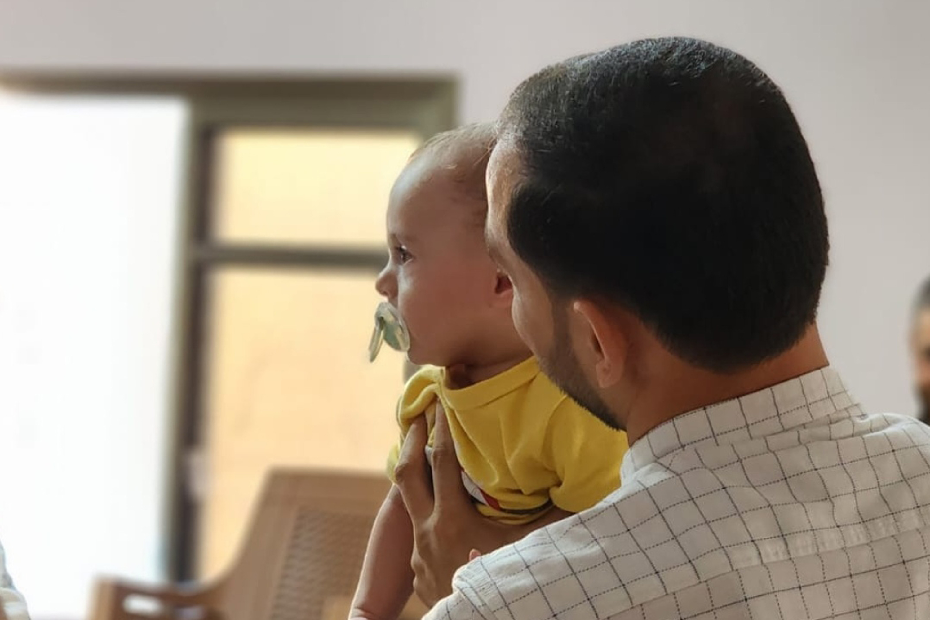 A photo of a man holding a baby