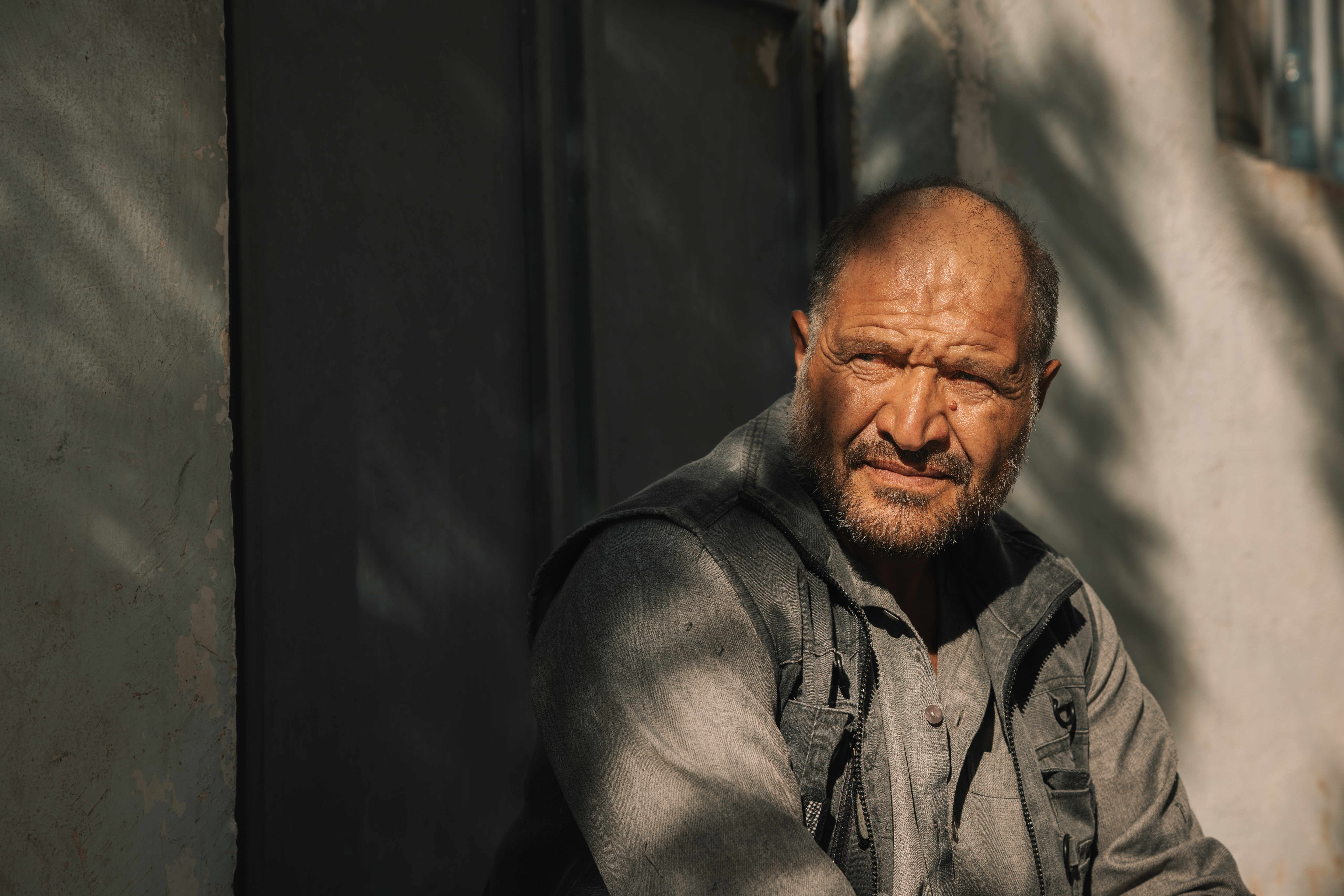 Manzar Shah, a father of eight from Badakhshan in northeastern Afghanistan, worked in a cleaning factory and flour mill in Iran until a fall from the third floor left him seriously injured. “Without a house, I feel myself sinking deeper into despair.” Photo: IOM 2025/Mohammad Osman Azizi