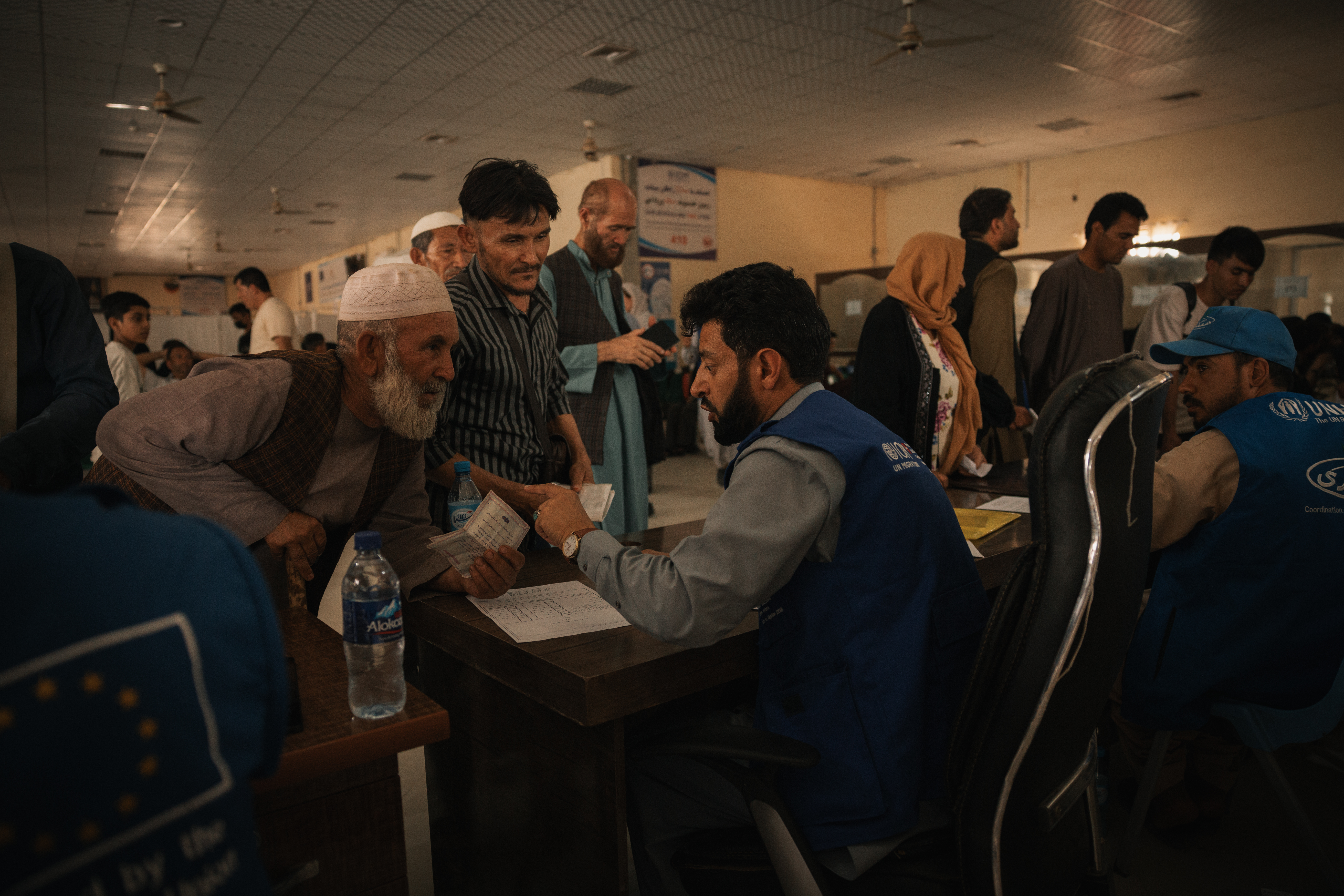 As evening falls, families arriving from Islam Qala wait to enter IOM’s transit centre in Herat. Photo: IOM 2025/Mohammad Osman Azizi
