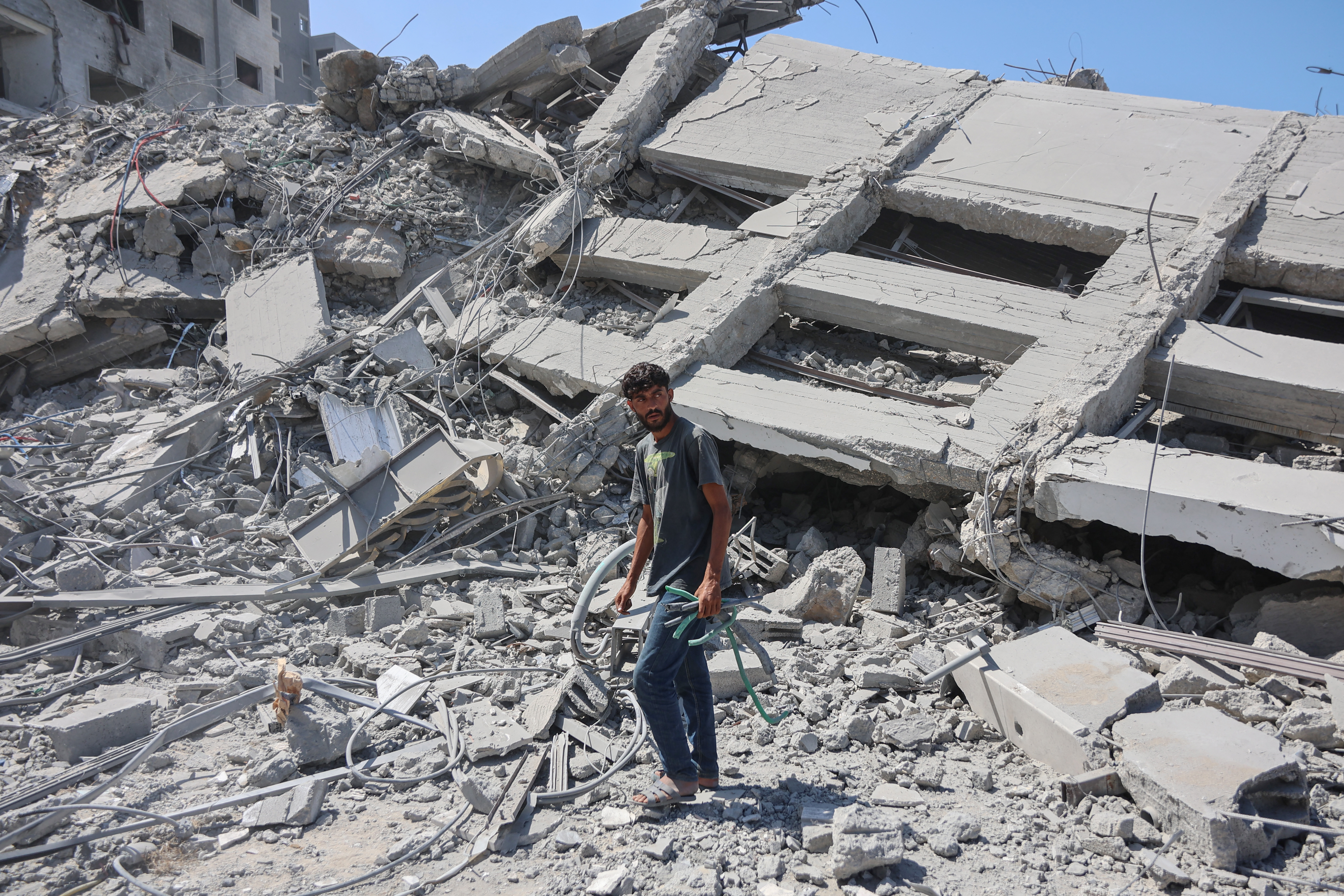 A Palestinian man walks through the rubble of the Tiba tower which crashed to the ground moments after Israeli strikes targeted the high-rise building in Gaza City on September 10, 2025.