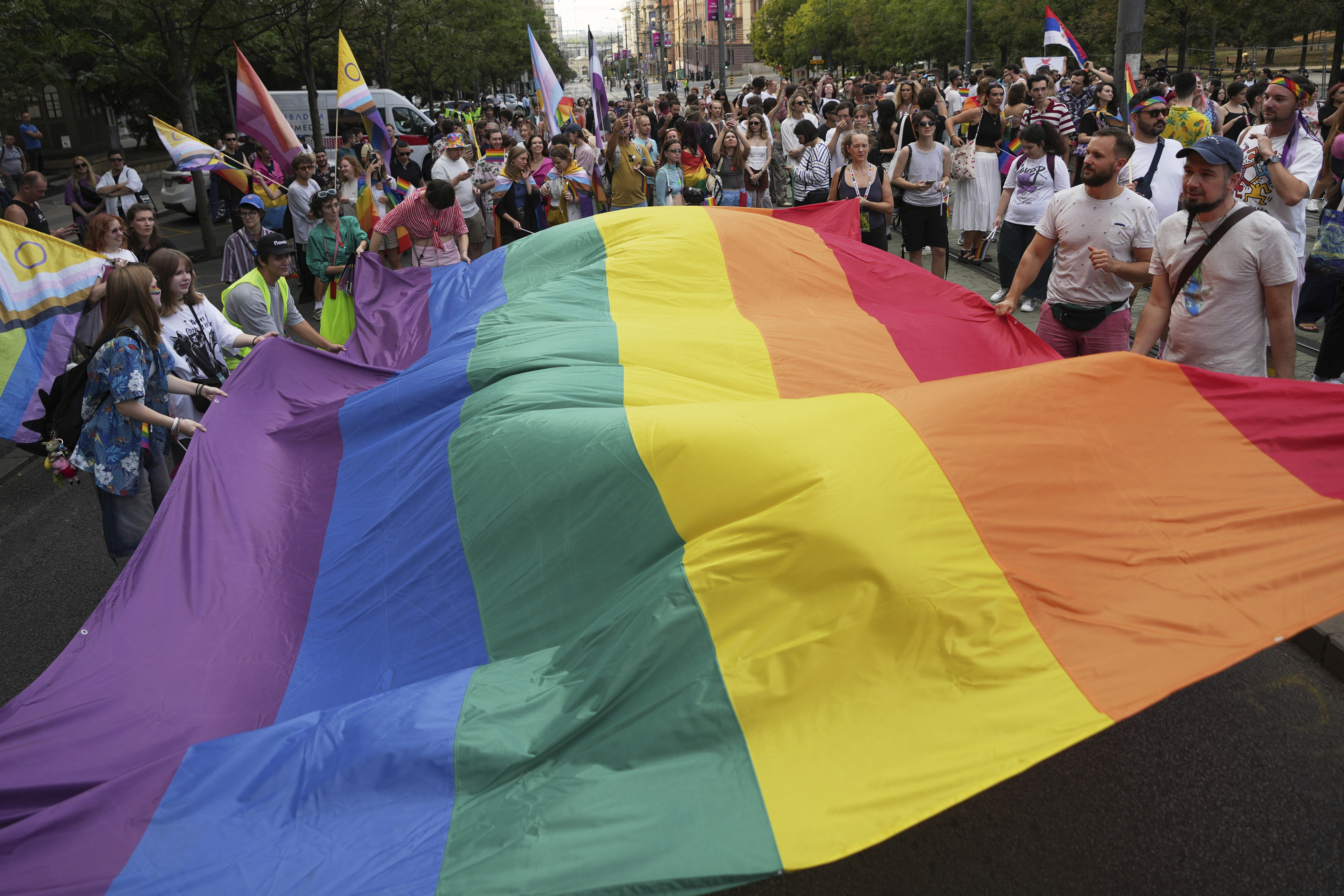 Participants hold up a rainbow flag during the Gay Pride march in Belgrade, Serbia