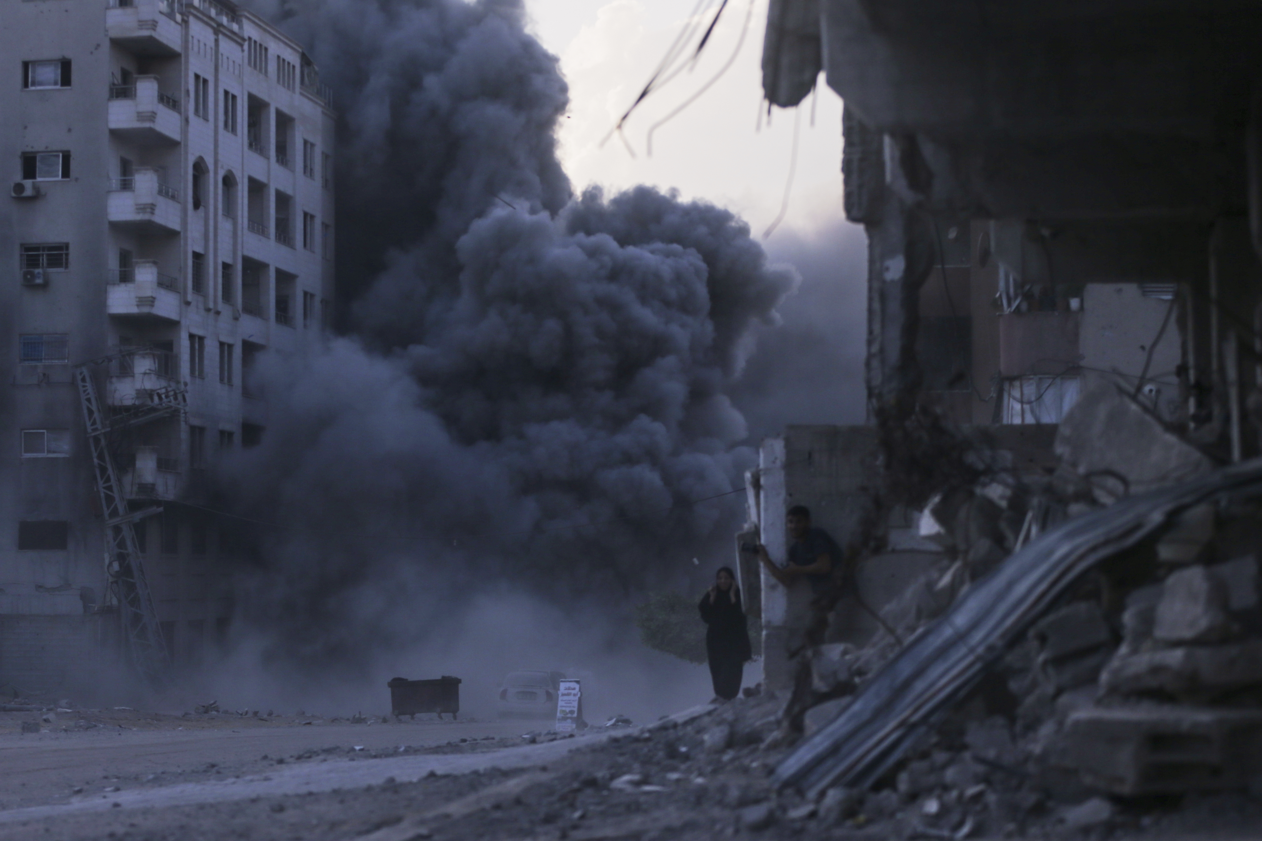 Palestinians take cover during an Israeli strike on a building in Gaza City, Sunday, Sept. 7, 2025, after the Israeli army issued a prior warning. (AP Photo/Yousef Al Zanoun)