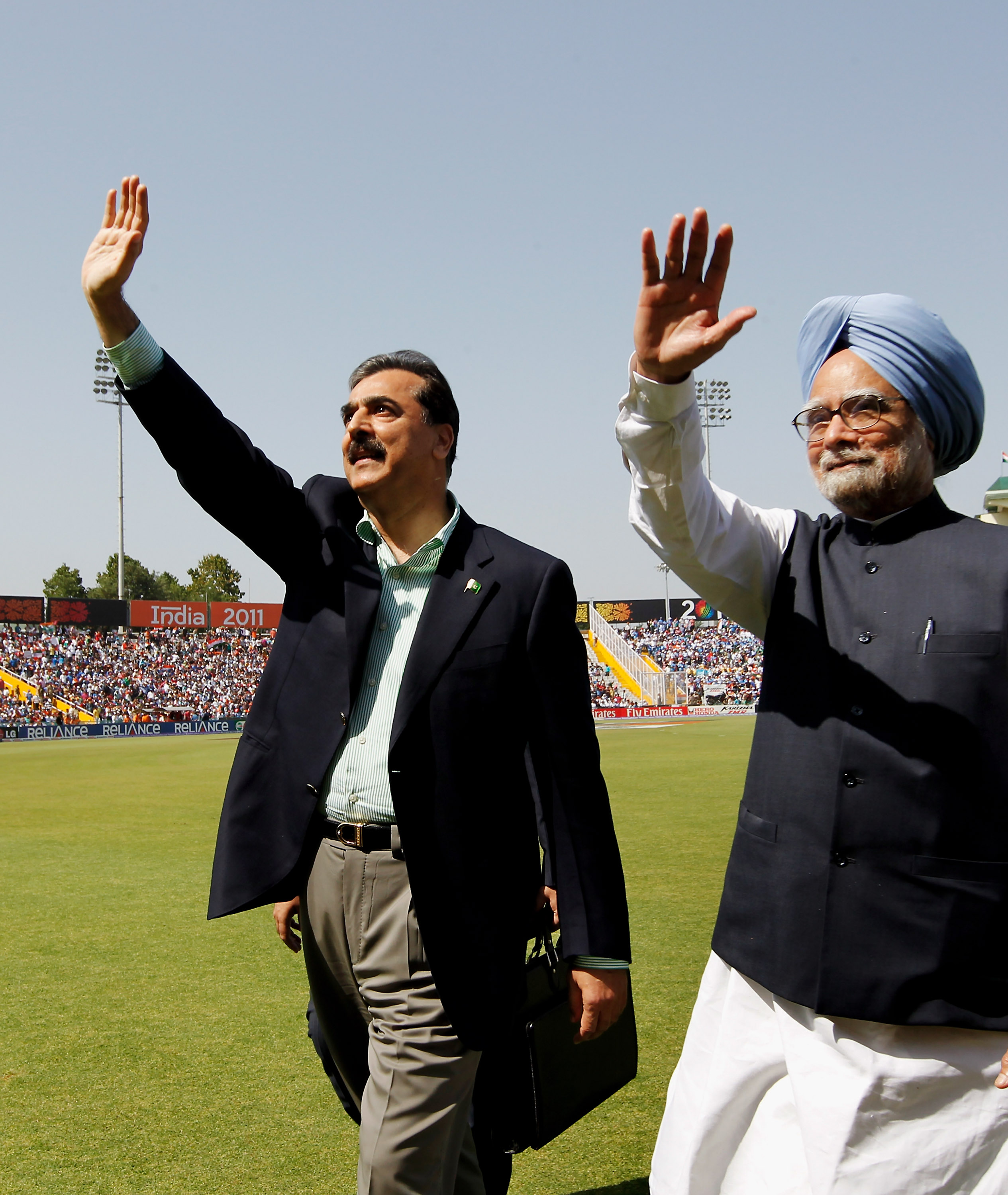 MOHALI, INDIA - MARCH 30: Prime Minister Syed Yusuf Raza Gilani of Pakistan and Prime Minister Manmohan Singh of India wave to spectators prior to the start of the 2011 ICC World Cup second Semi-Final between India and Pakistan at Punjab Cricket Association (PCA) Stadium on March 30, 2011 in Mohali, India. (Photo by Daniel Berehulak-Pool/Getty Images)