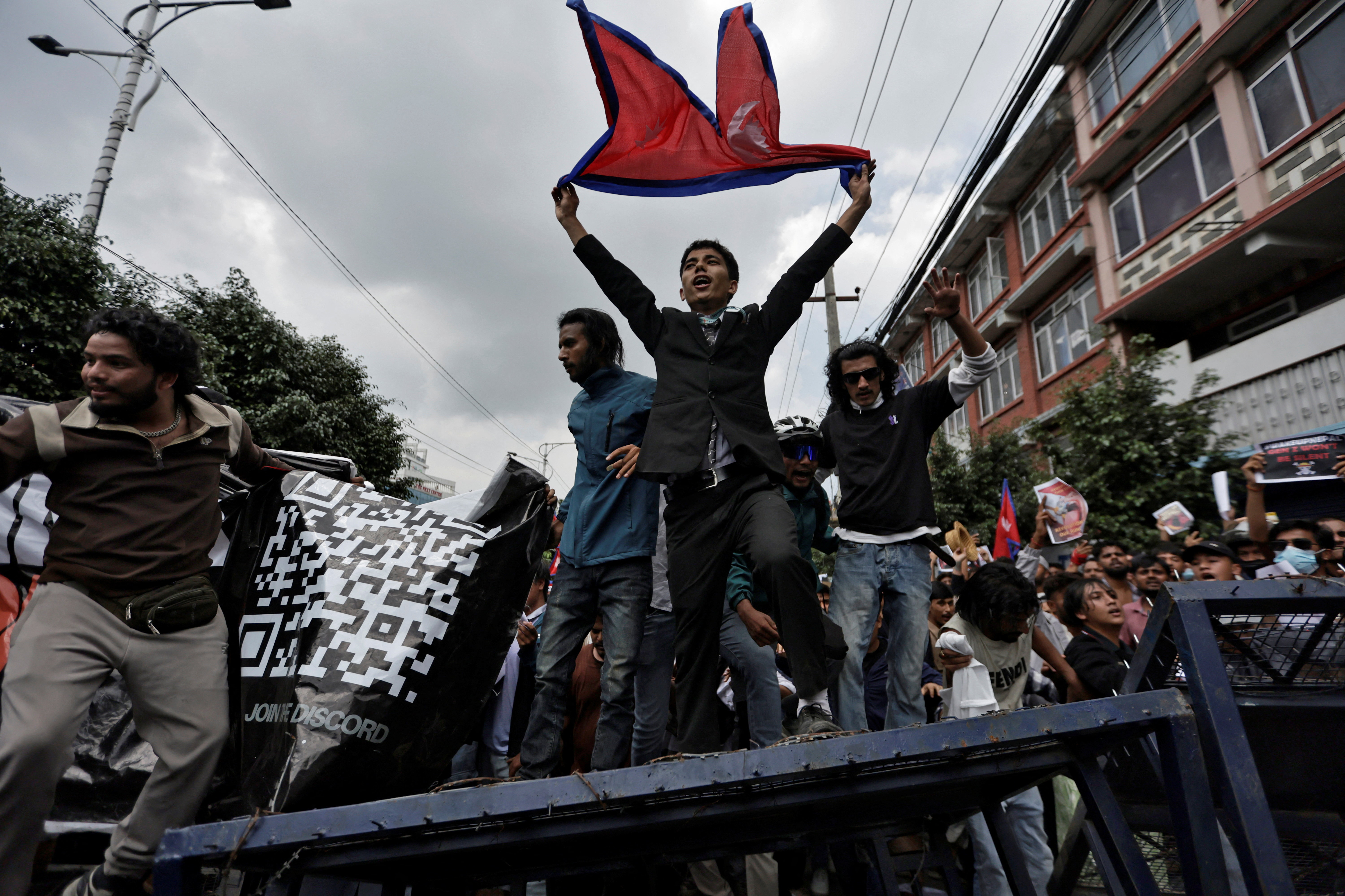 Demonstrators shout slogans as they stand on a barricade during a protest against corruption and the government’s decision to block several social media platforms, in Kathmandu, Nepal
