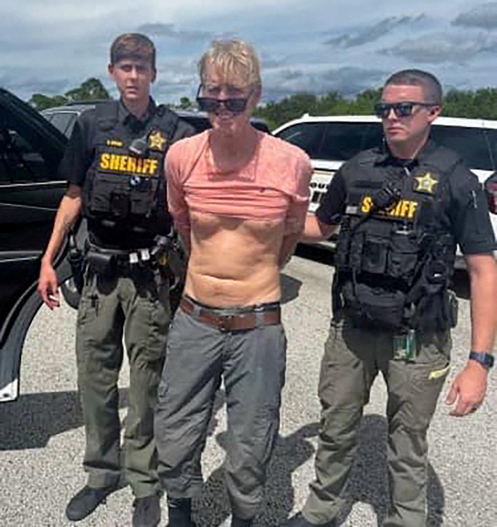 FILE PHOTO: Ryan W. Routh, suspected of attempting to assassinate Republican presidential nominee and former U.S. President Donald Trump at his West Palm Beach golf course, stands handcuffed between two Martin County Sheriff's office deputies after his arrest during a traffic stop near Palm City, Florida, U.S., September 15, 2024. Martin County Sheriff's Office/Handout via REUTERS THIS IMAGE HAS BEEN SUPPLIED BY A THIRD PARTY/File Photo