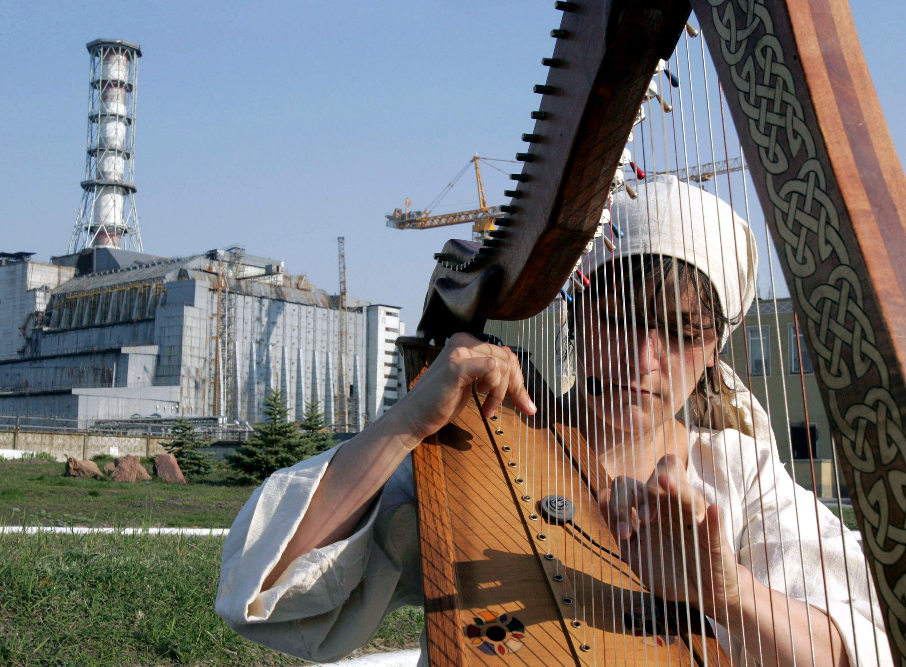 A member of a French group of musicians plays the harp during the performance "La diagonale de Tchernobyl," directed by Bruno Boussagol, in front of the shut-down fourth reactor of the Chernobyl nuclear power station April 25, 2006. [The Number Four nuclear reactor blew up 20 years ago. The reactor, in what was then the Soviet republic of Ukraine, spewed a huge cloud of radioactive dust over much of Europe in what was the worst nuclear accident the world has ever seen.]
