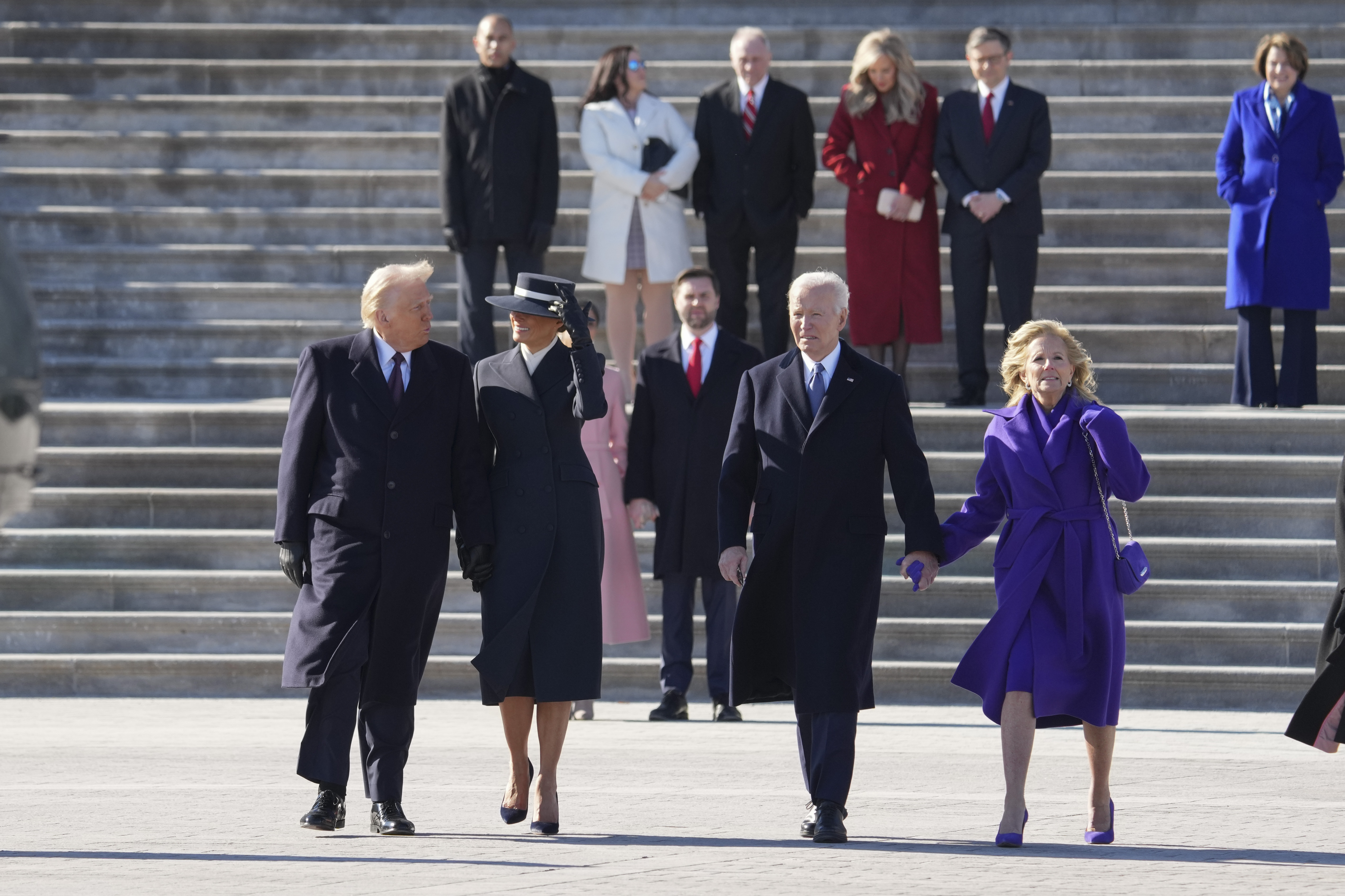 Joe Biden holds hands with Jill Biden as they walk alongside Donald Trump and Melania Trump