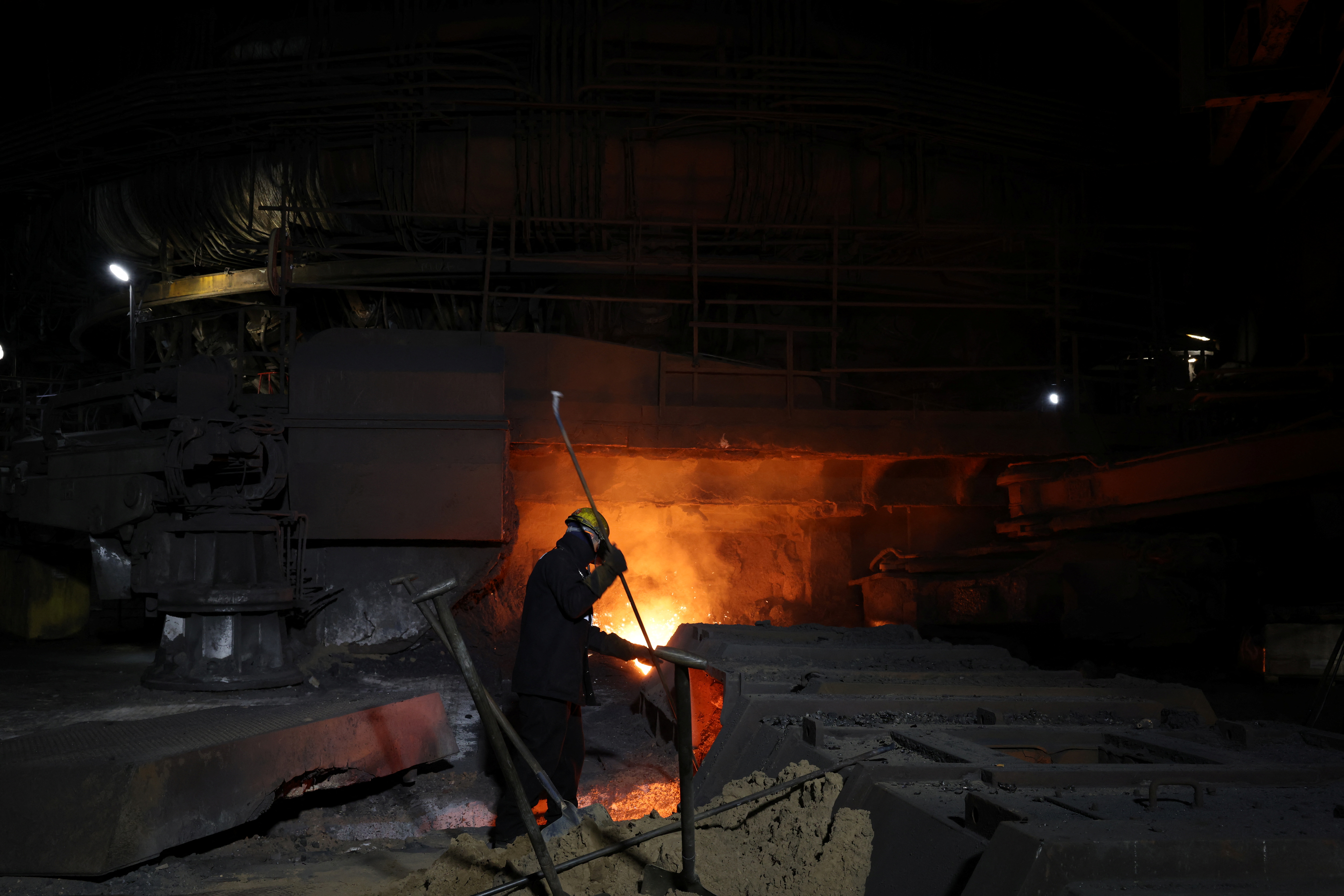 A worker works at one of the blast furnaces at British Steel's steelworks.