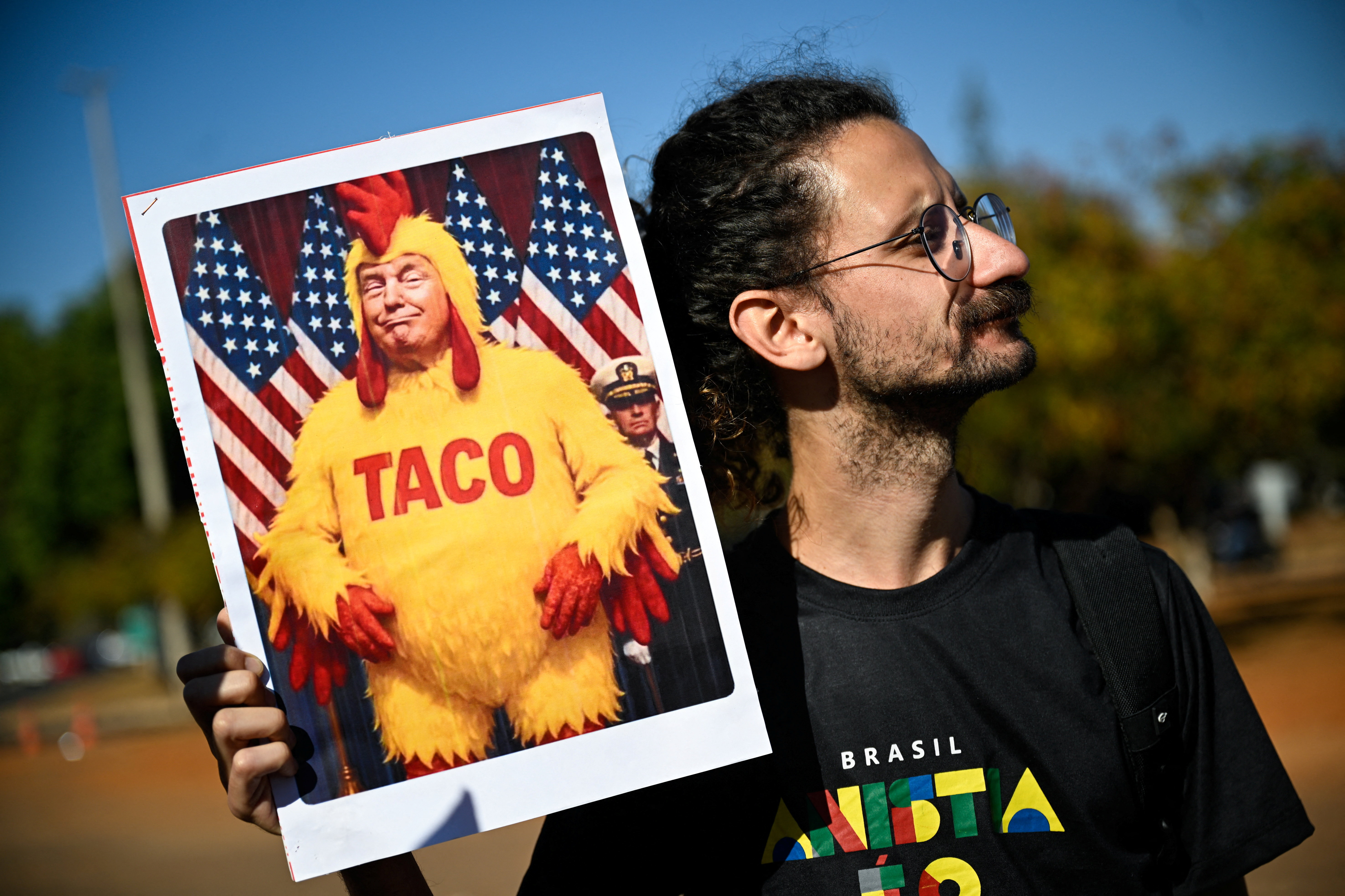 A demonstrator holds a placard depicting US President Donald Trump.