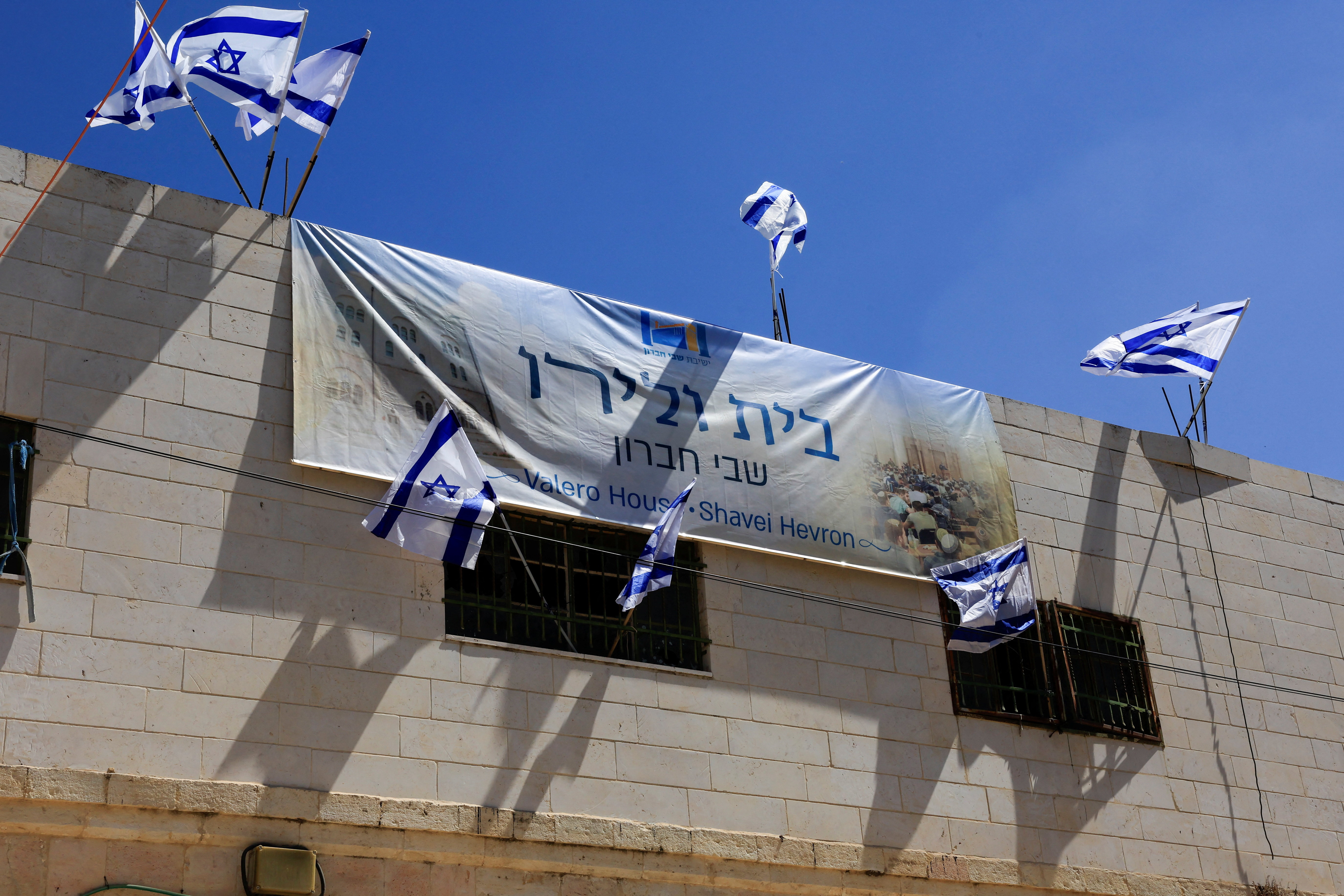 Israeli flags flutter over a house which was taken over by Israeli settlers in the old city, in Hebron in the Israeli-occupied West Bank September 3,2025. REUTERS/Mussa Qawasma