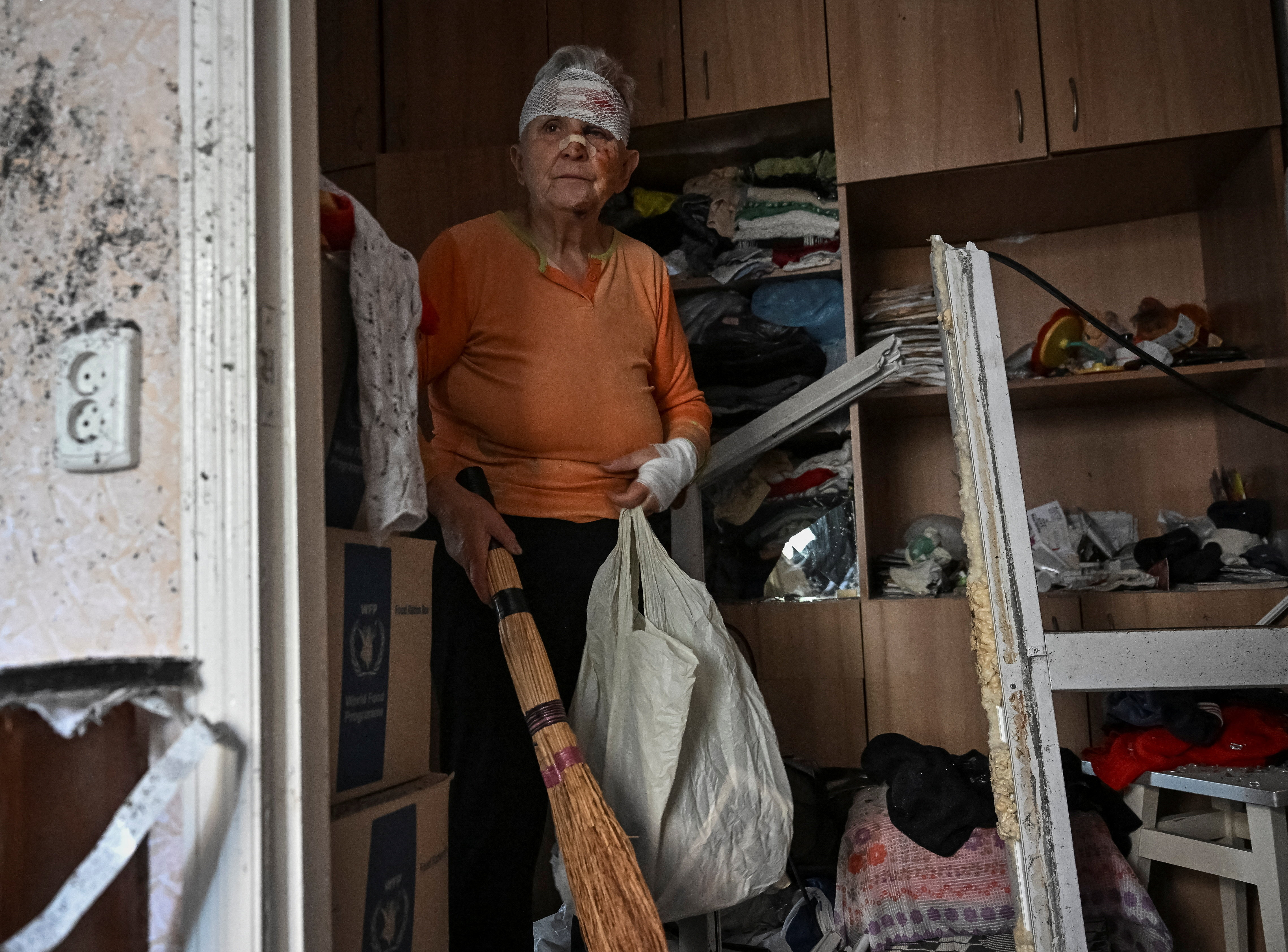 A wounded resident, Nataliya, 82, cleans her flat in an apartment building damaged by a Russian drone strike, amid Russia's attack on Ukraine, in Zaporizhzhia, Ukraine October 5, 2025. REUTERS/Stringer