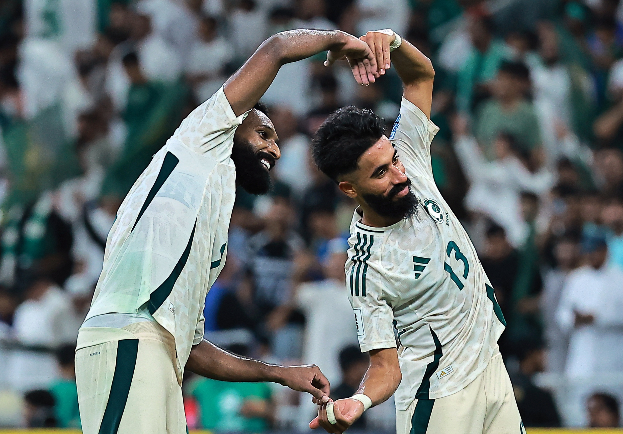Saudi Arabia's Feras Al-Brikan celebrates scoring their third goal with Saudi Arabia's Nawaf Boushal