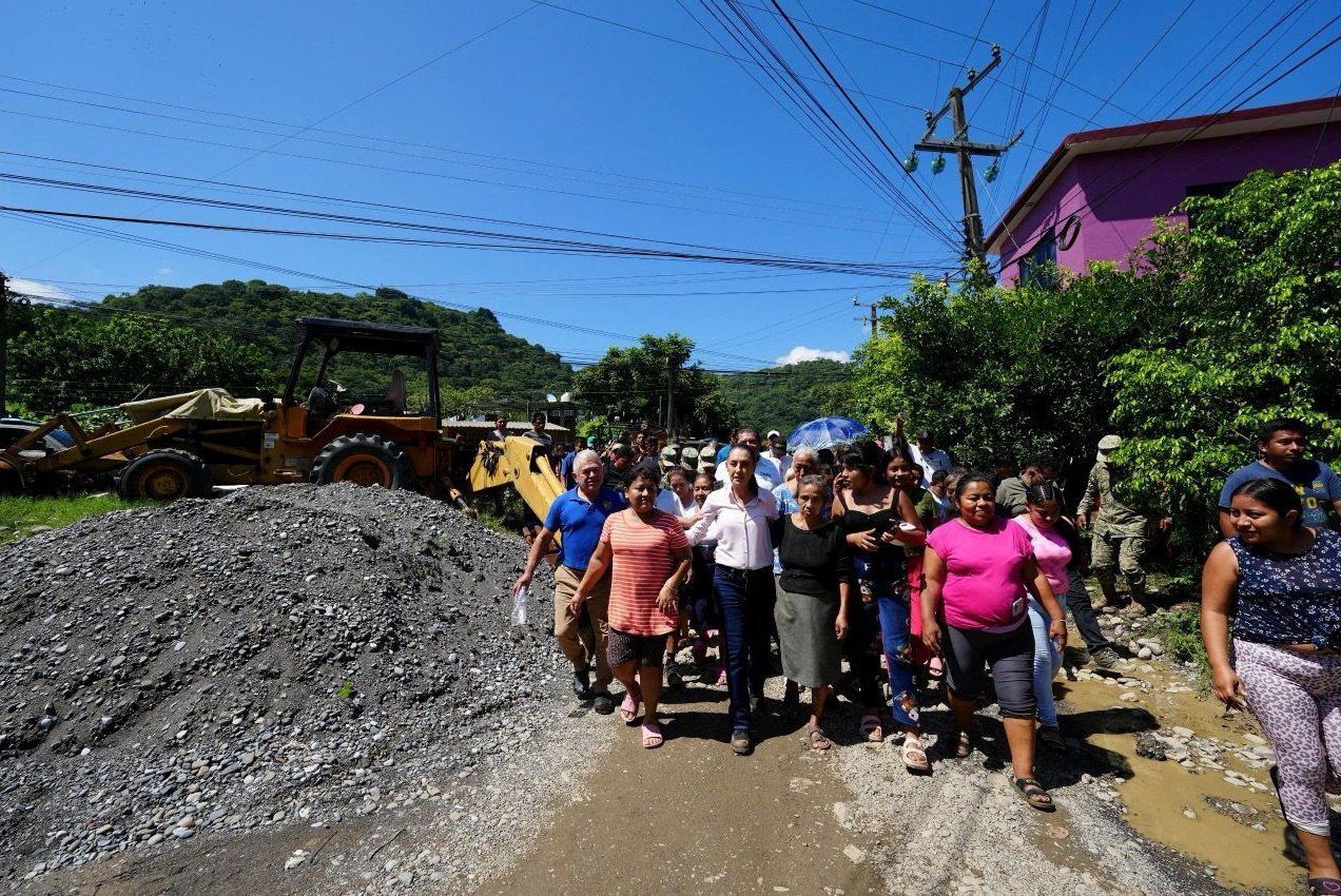 Mexico's President Claudia Sheinbaum walks with residents while visiting areas impacted by torrential rains in La Ceiba, Mexico October 12, 2025.