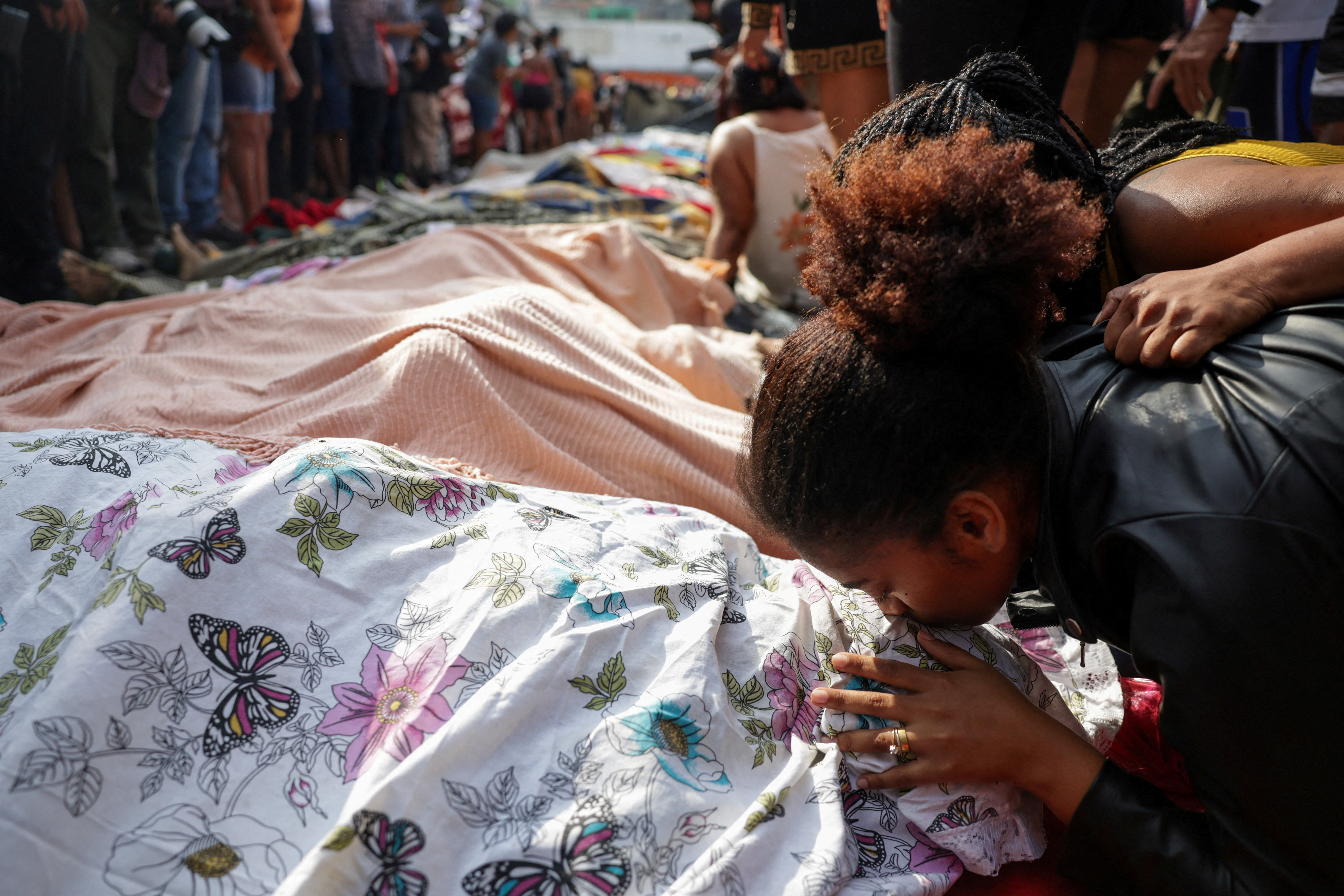 SENSITIVE MATERIAL. THIS IMAGE MAY OFFEND OR DISTURB A mourner kisses a covered body, the day after a deadly police operation against drug trafficking at the favela do Penha, in Rio de Janeiro, Brazil, October 29, 2025. REUTERS/Ricardo Moraes TPX IMAGES OF THE DAY