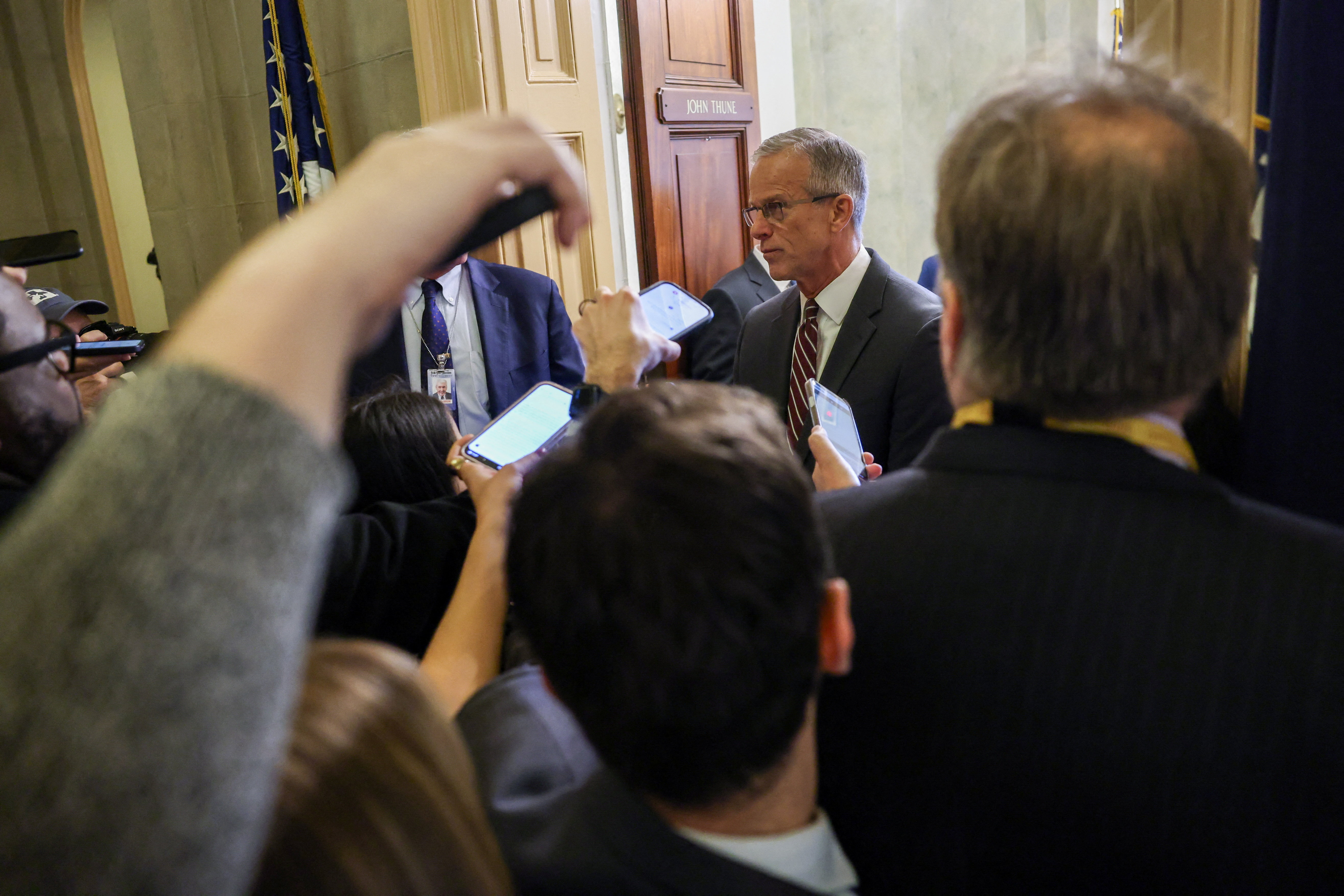 Reporters surround John Thune at his Congressional office door.