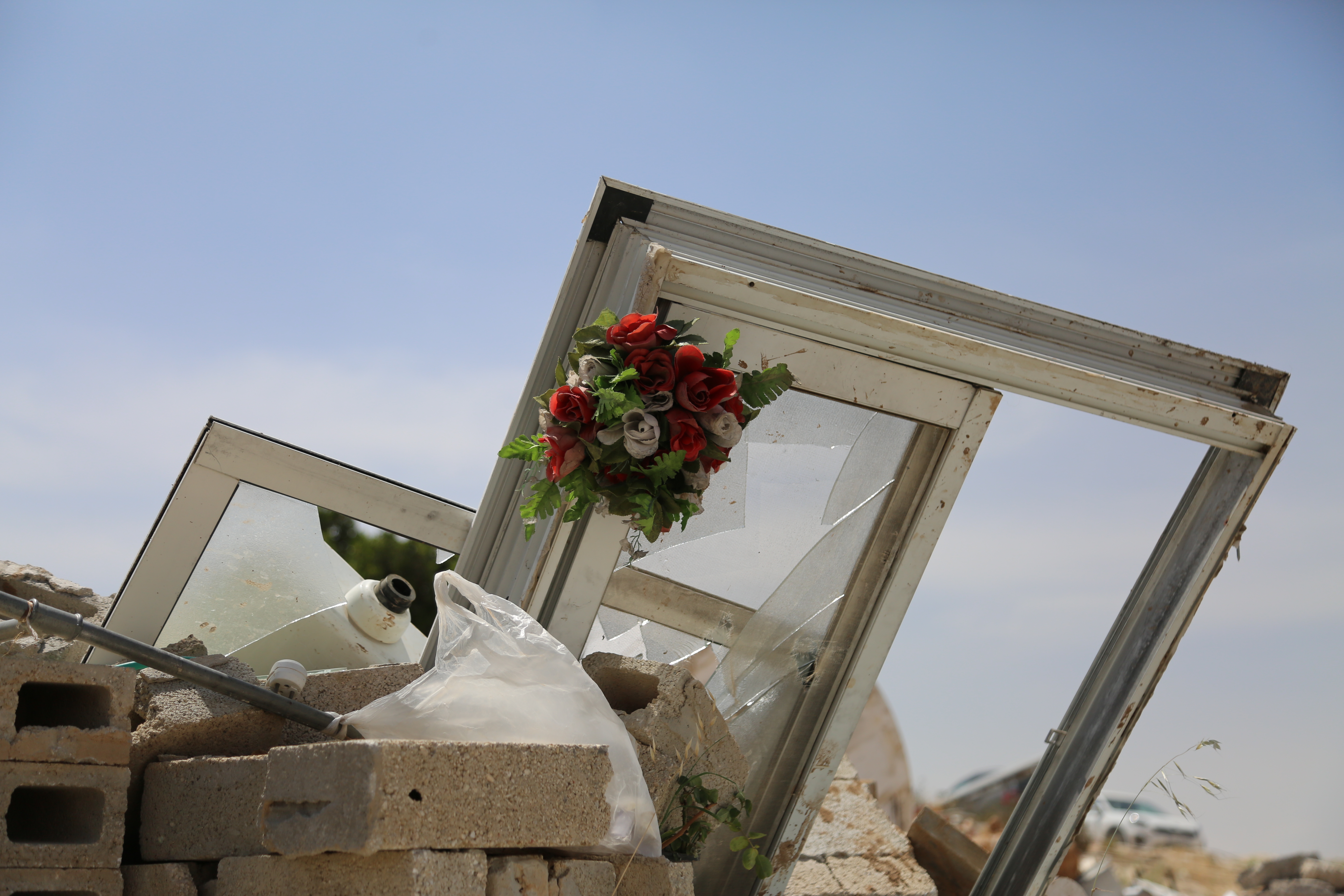 A door frame with a flower sits on top of rubble