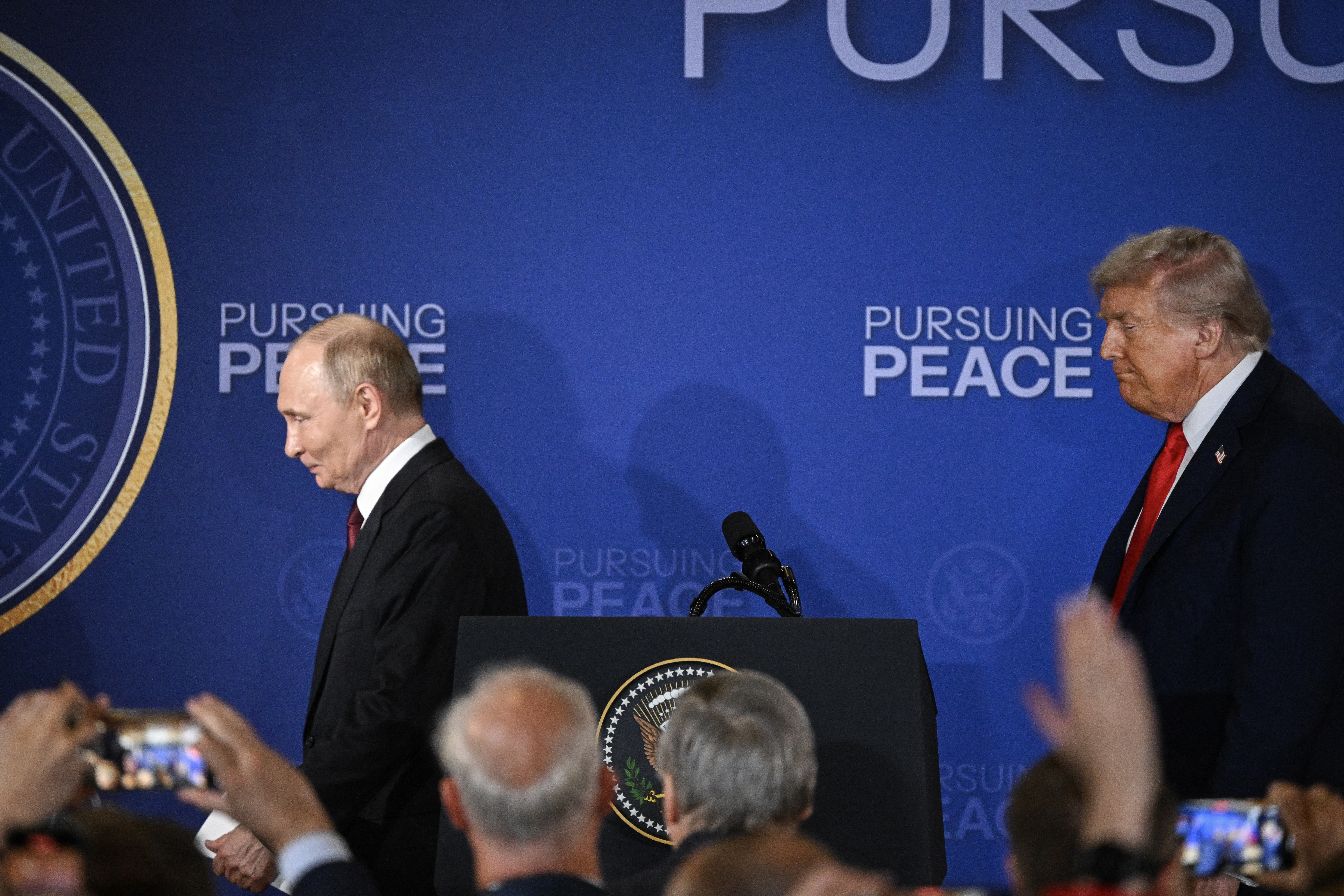 US President Donald Trump (R) and Russian President Vladimir Putin walk away after delivering a joint news conference.