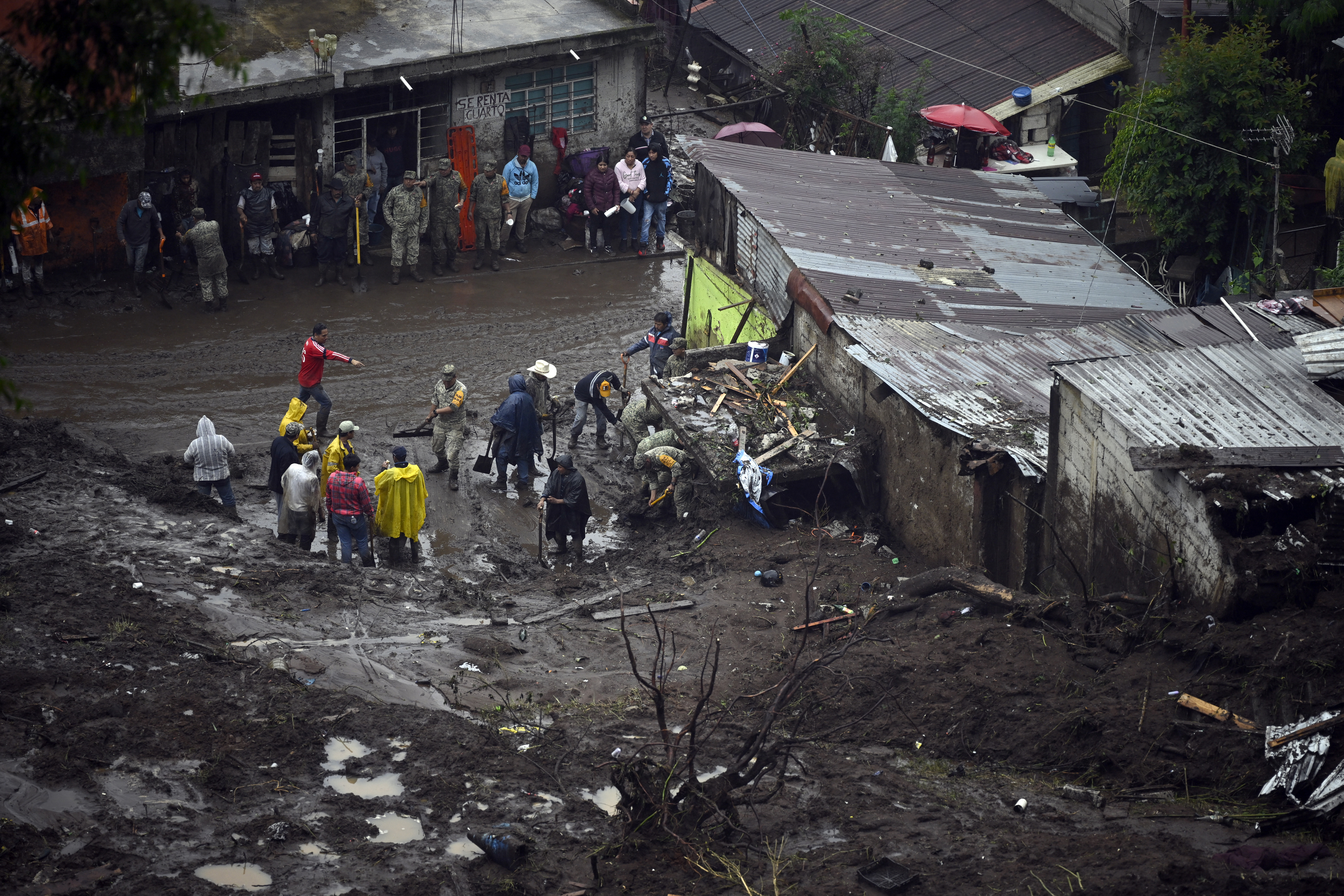 People work on a damaged house due to the rains in the municipality of Huauchinango, Puebla State, Mexico on October 11, 2025. The death toll from heavy rains in Mexico rose to 37 on Saturday after nine more fatalities were confirmed, the Mexican government reported. (Photo by Alfredo ESTRELLA / AFP)