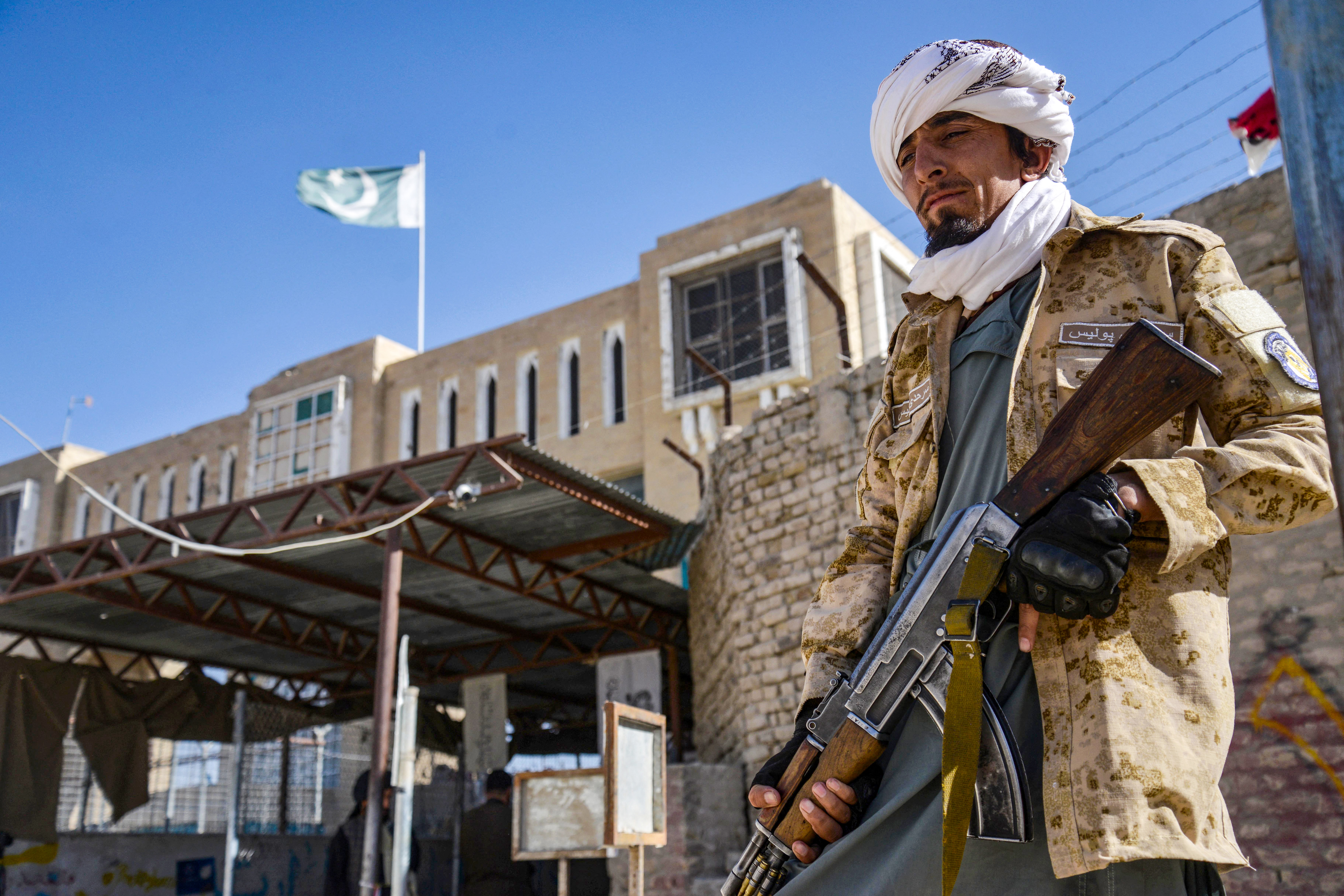 An Armed Taliban security personnel stands guard near the closed gate of the zero point border crossing between Afghanistan and Pakistan at Spin Boldak district in Kandahar province