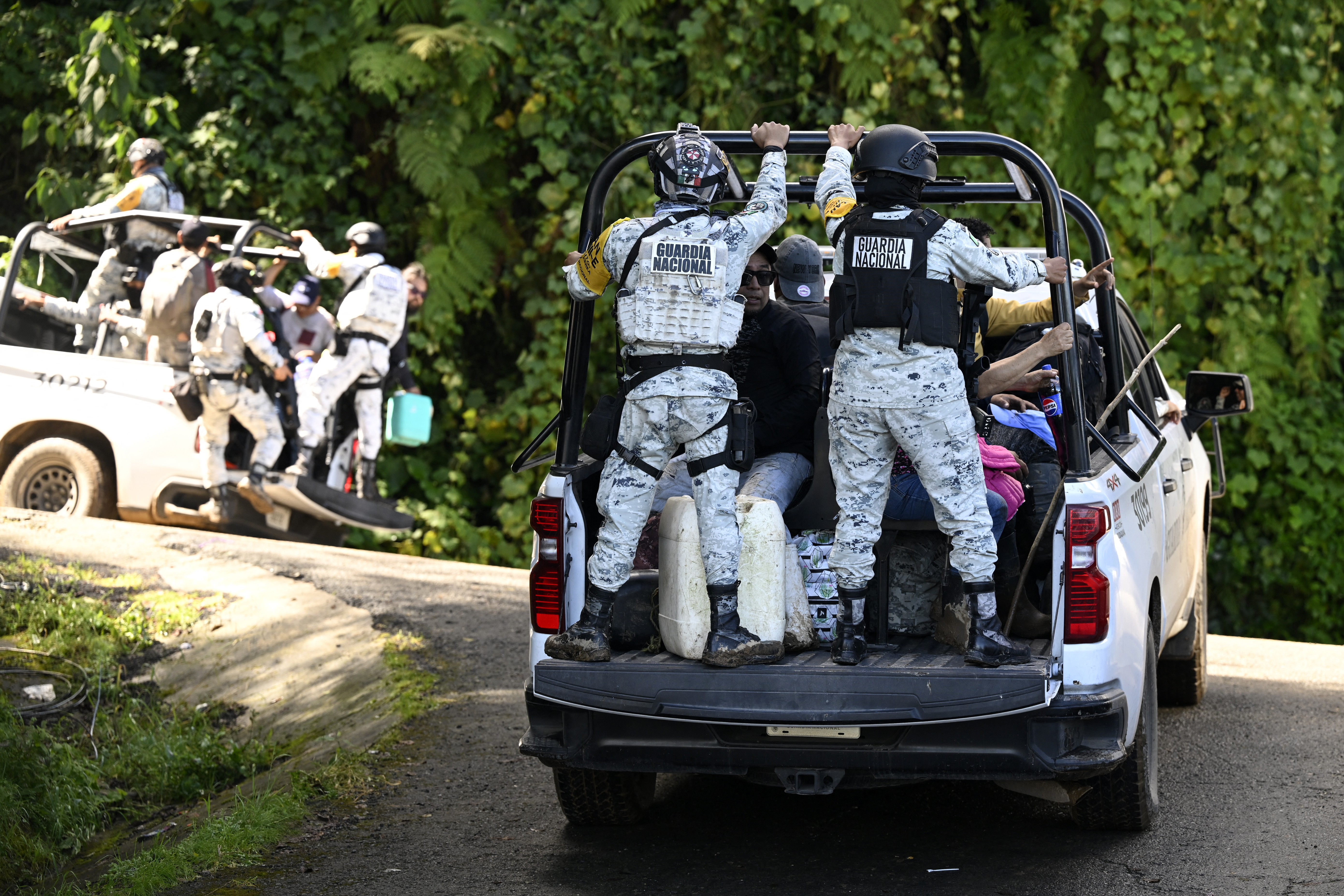 Members of the National Guard transport residents along the TulancingoTenango road to Tulancingo after heavy rains in Hidalgo state, Mexico, on October 12, 2025. The death toll from heavy rains in Mexico rose to 44 after the Mexican government confirmed three more fatalities on Sunday, as civilian and military rescuers struggle to clear roads and reach cut-off communities. (Photo by Alfredo ESTRELLA / AFP)
