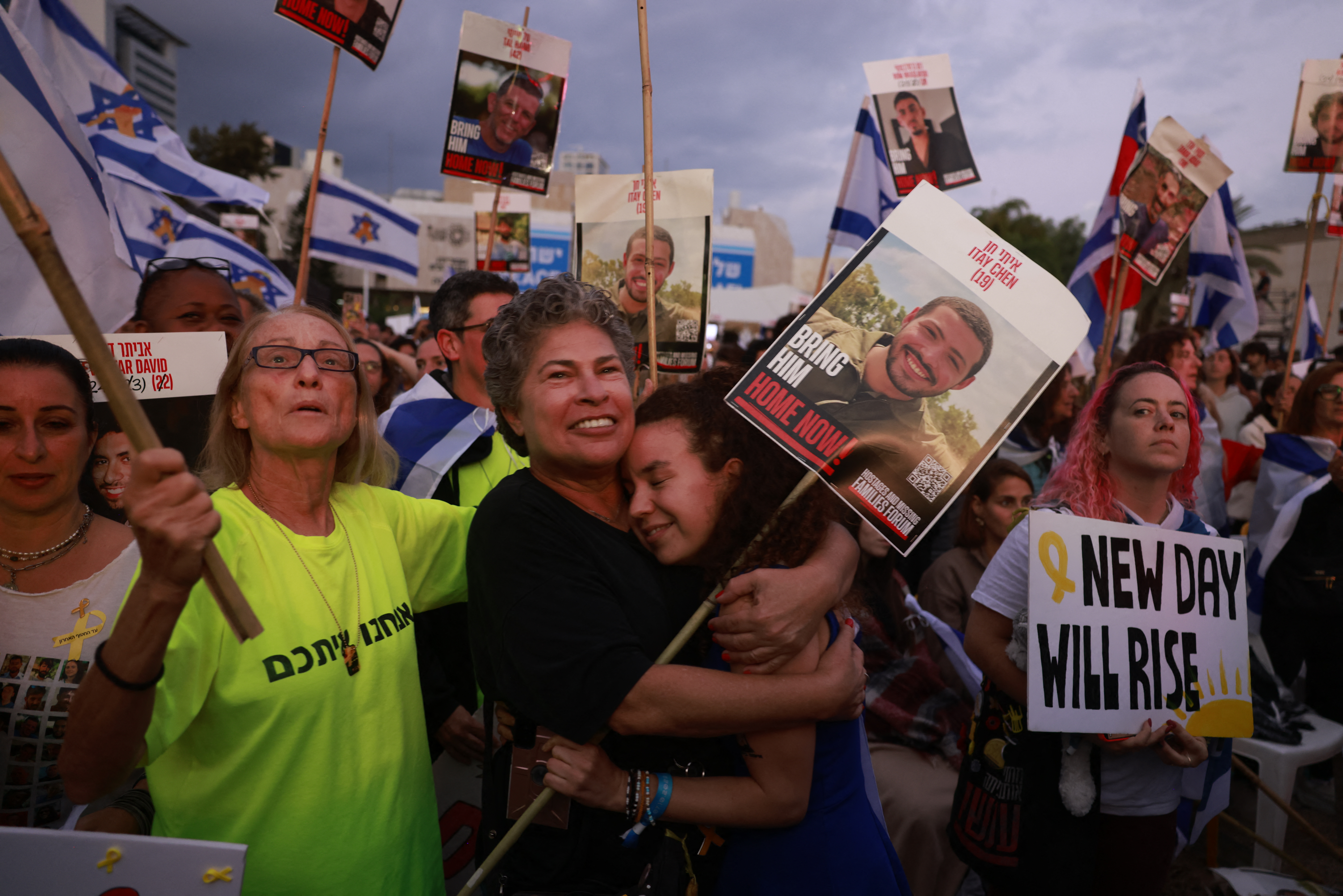 People holding up portraits of Israeli hostages still held in Gaza and Israeli flags gather at Hostage Square in Tel Aviv