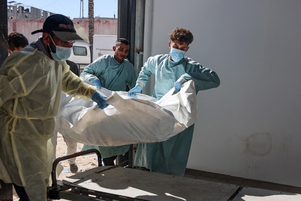 Hospital workers transport the remains of a Palestinian released by Israel under a Gaza ceasefire and hostage exchange deal, to the morgue of Nasser hospital in Khan Yunis in the southern Gaza Strip, on October 18, 2025. Israel returned the bodies of 15 Palestinians to Gaza on October 18, bringing the total number handed over to 135, the health ministry in the Hamas-run territory said.