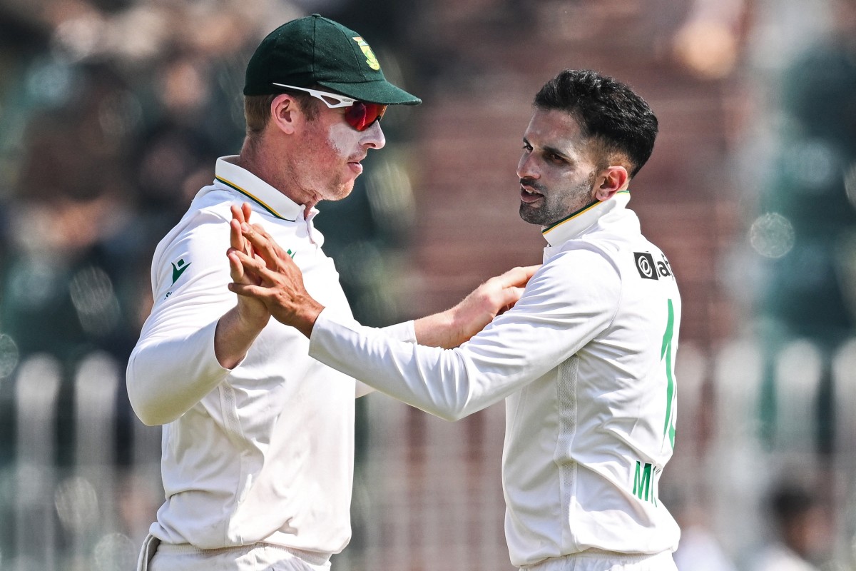 South Africa's Keshav Maharaj (R) celebrates with Simon Harmer after taking the wicket of Pakistan's Saud Shakeel during the second day of the second Test cricket match between Pakistan and South Africa at the Rawalpindi Cricket Stadium in Rawalpindi on October 21, 2025. (Photo by Aamir QURESHI / AFP)