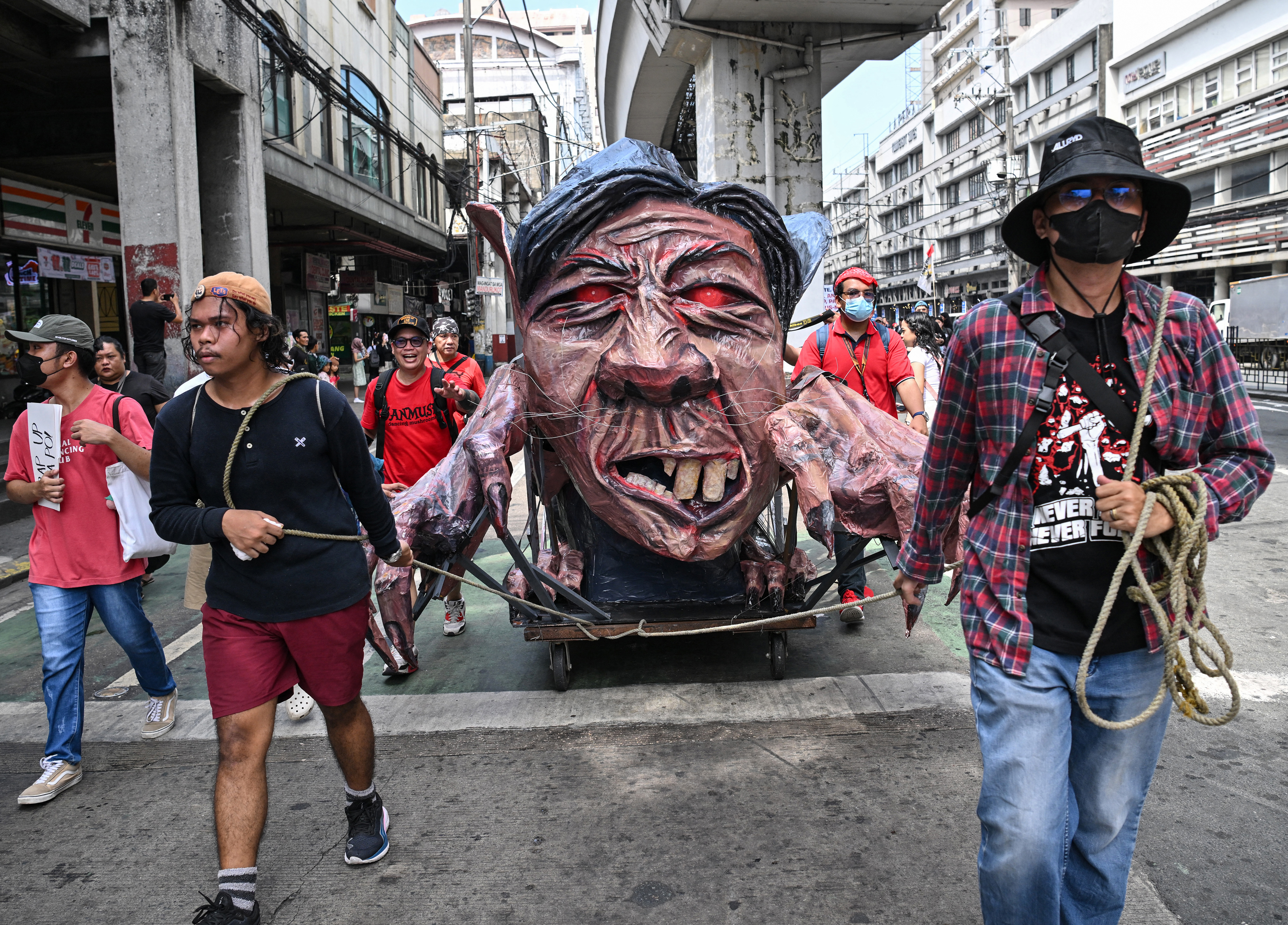 Protesters pull a cart with an effigy of Philipines' President Ferdinand Marcos during a farmer-led anti-corruption demonstration near Malacanang Palace in Manila
