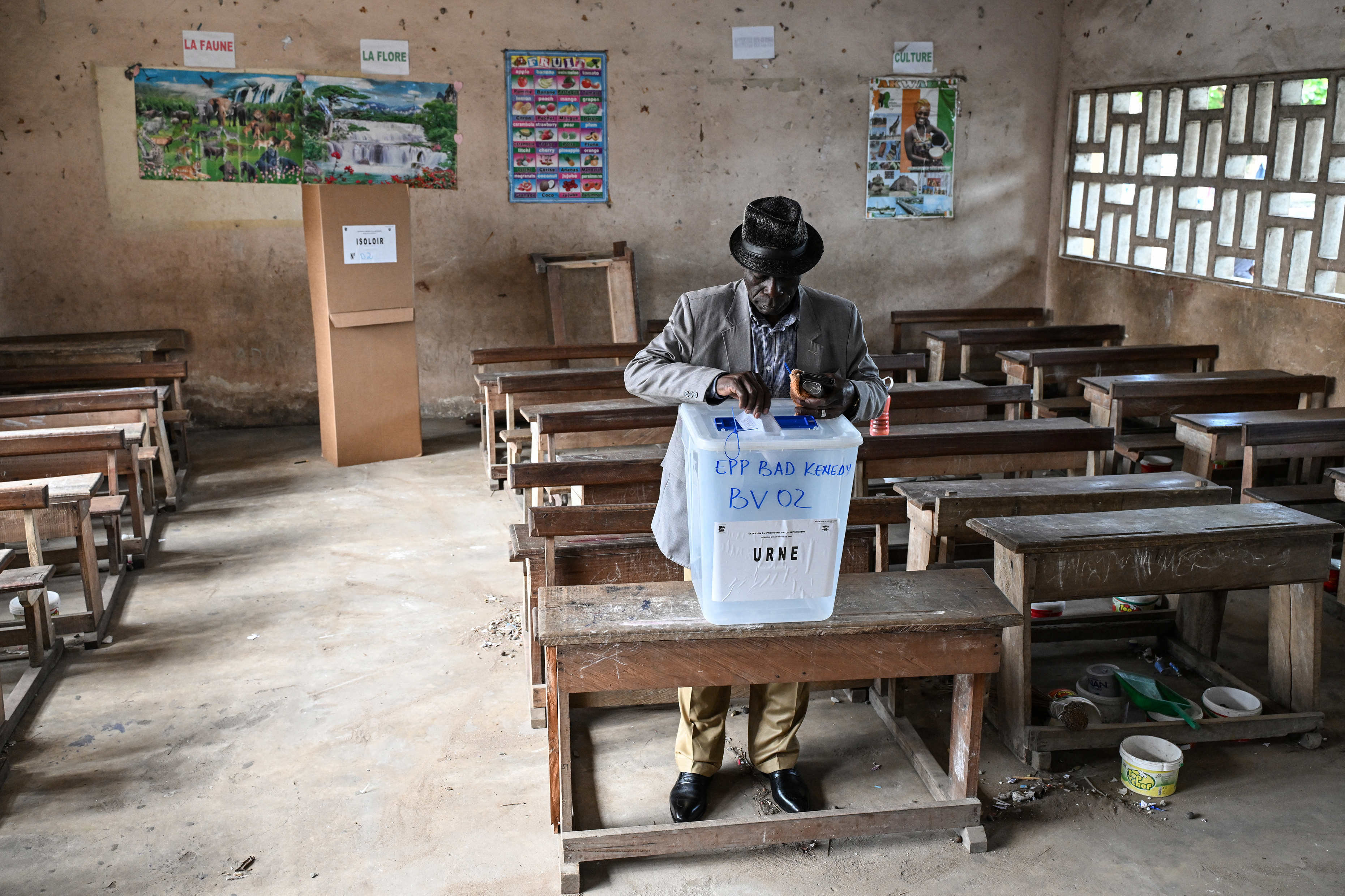 A voter casts his ballot at the Kenedy school group polling station in Cocody, Abidjan