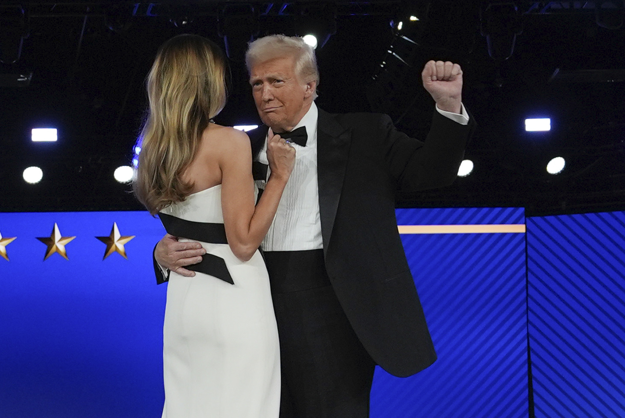 Donald Trump raises a fist as he dances with Melania Trump