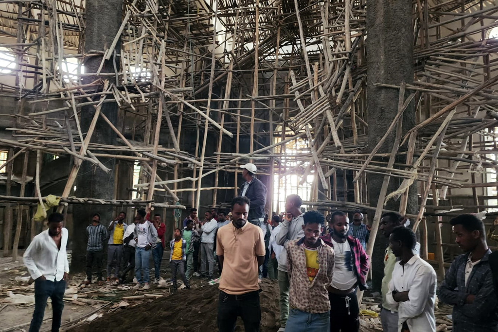 Worshippers stand inside the Menjar Shenkora Arerti Mariam Church under construction that collapsed